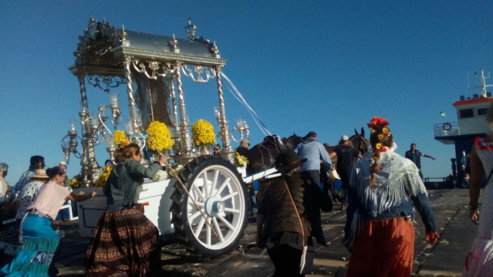 La carreta del Simpecado de la Hermandad del Rocío de La Línea, subiendo a una de las barcazas en la playa de Bajo de Guía ayer por la mañana.