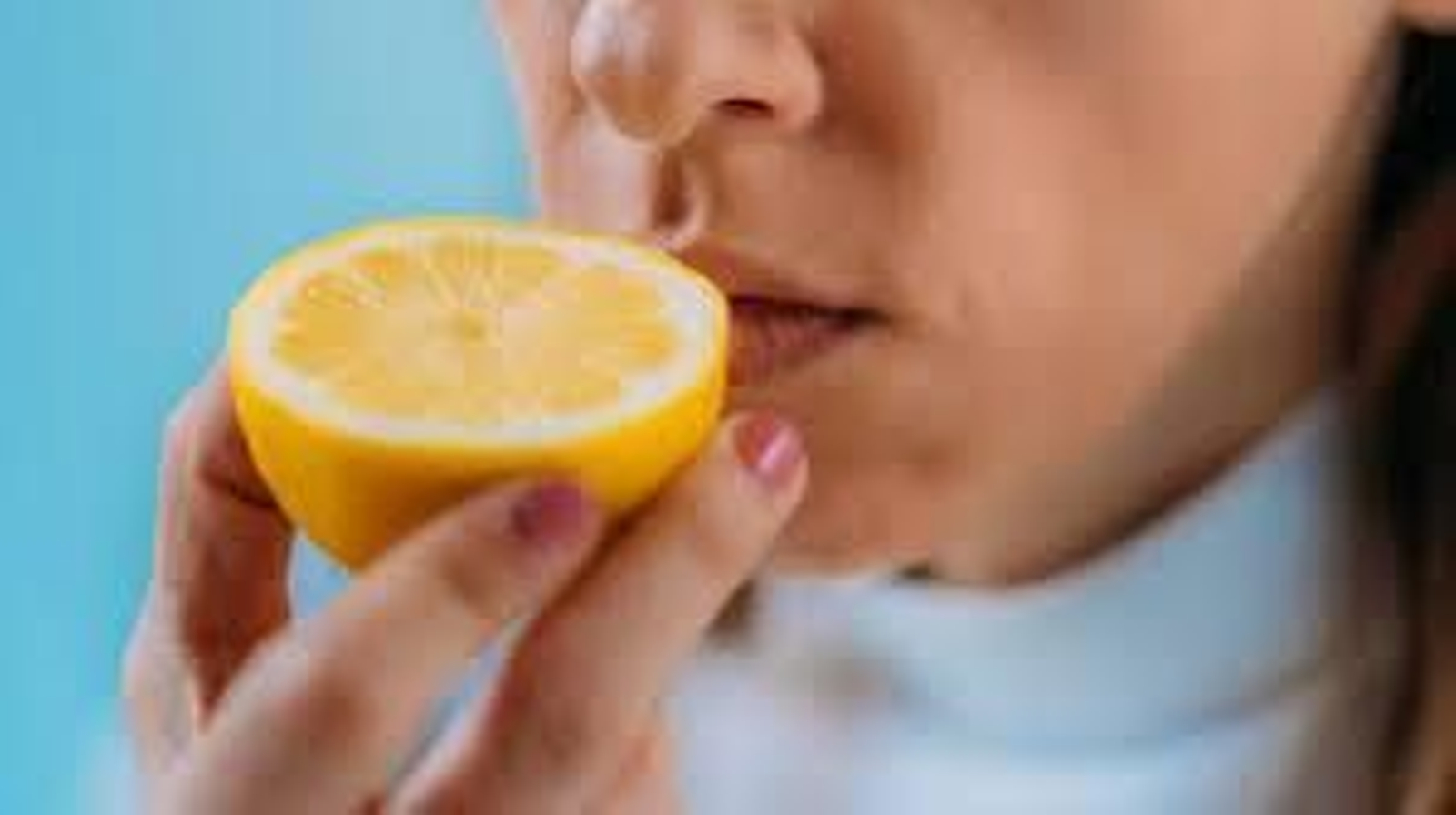 Una mujer huele un limón