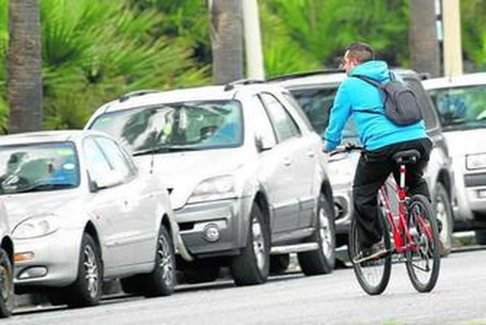 Un hombre circula en bicicleta por una calle linense.