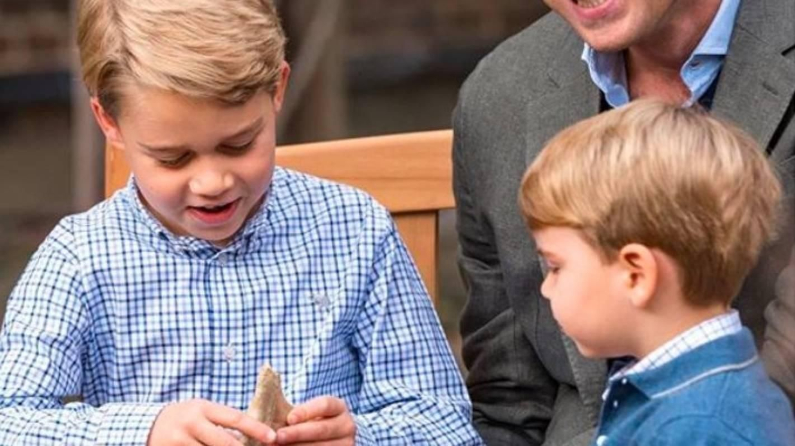 El príncipe Jorge mira asombrado el fósil que le obsequió David Attenborough.