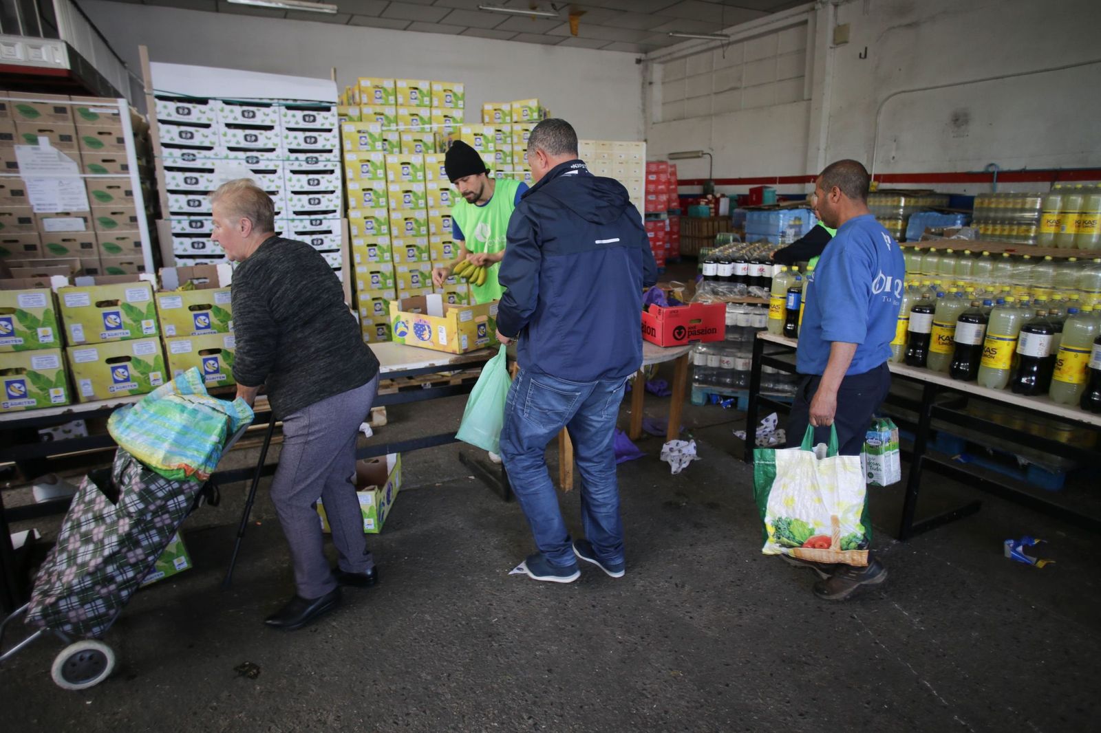 Voluntarios atienden a las personas que vienen a buscar comida a un Banco de Alimentos.