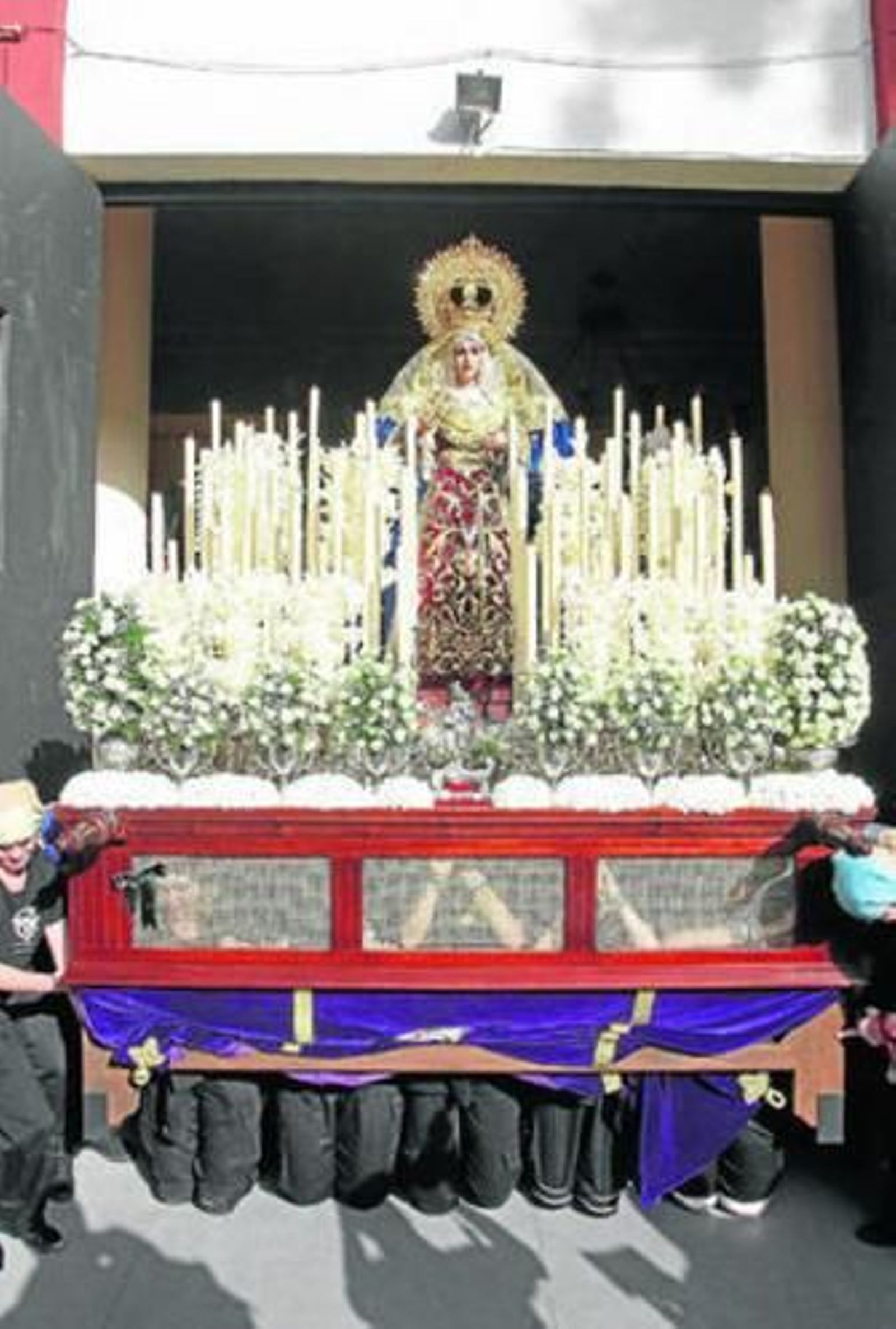 Las costaleras de rodillas sacando a La Trinidad.