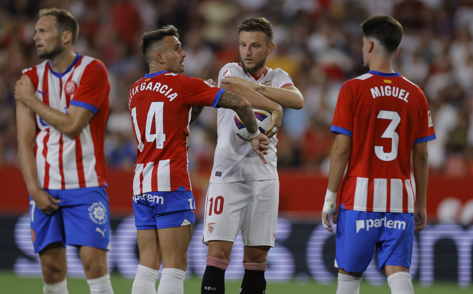Rakitic discute con Aleix García sobre la parte del brazo de David López donde rebotó el balón.