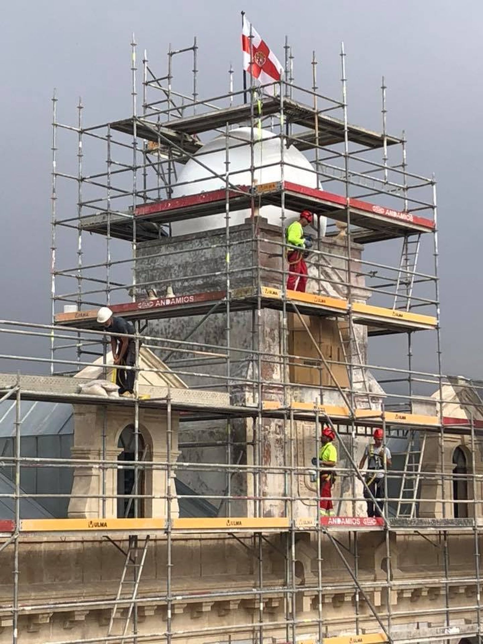 Trabajadores en la cúpula central, en la que se encuentra el reloj, tapado, sobre el Escudo de la Ciudad.
