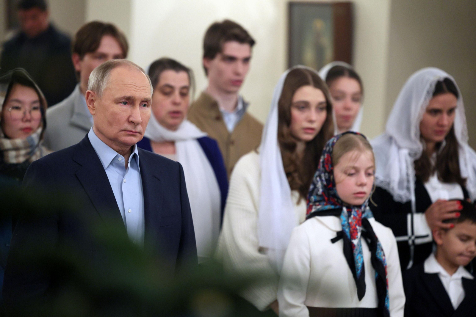 El presidente ruso, Vladimir Putin, en la misa del Gallo junto a familiares de caídos en la guerra.
