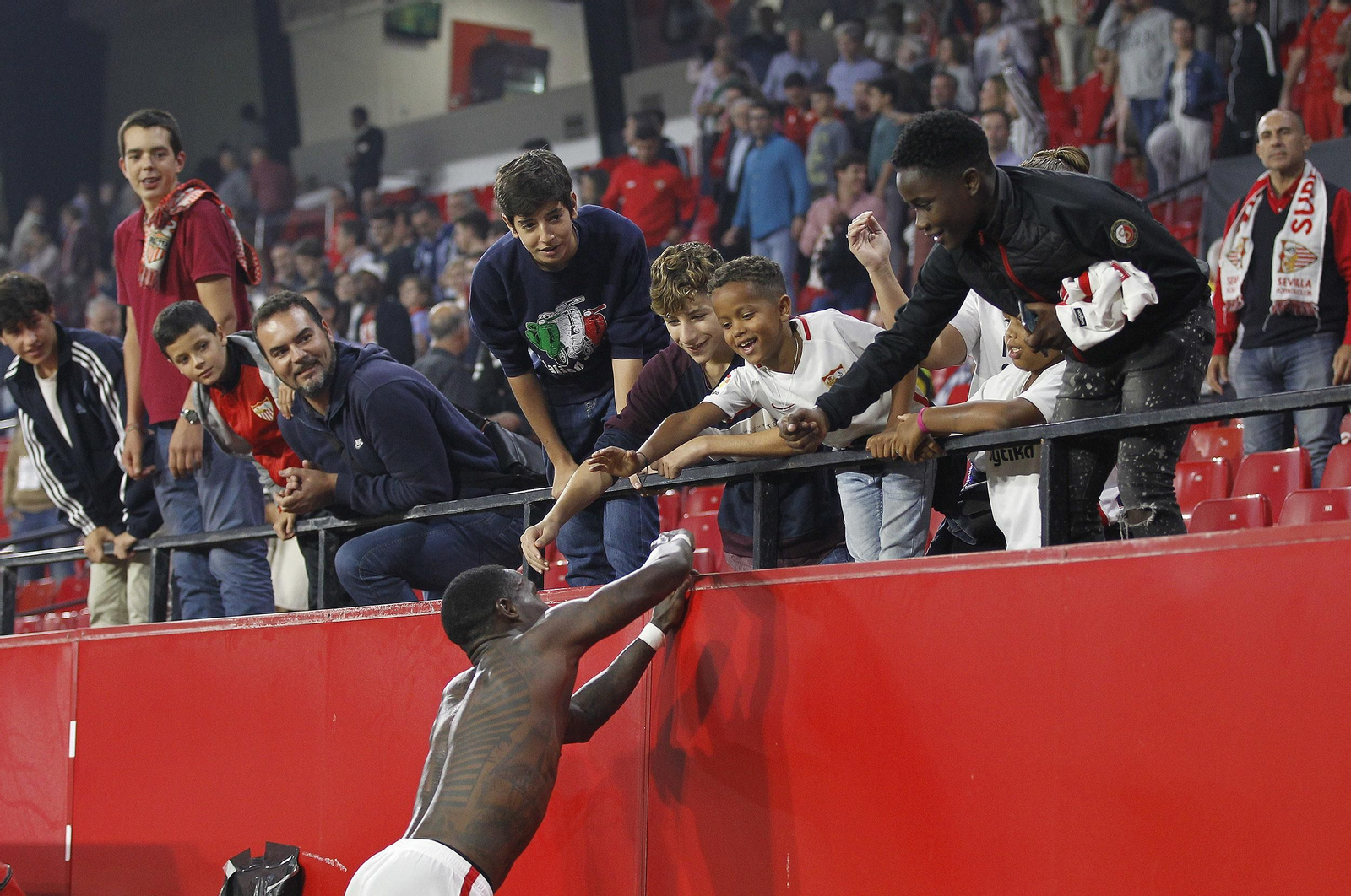 Promes firma autógrafos a unos aficionados tras regalar su camiseta.