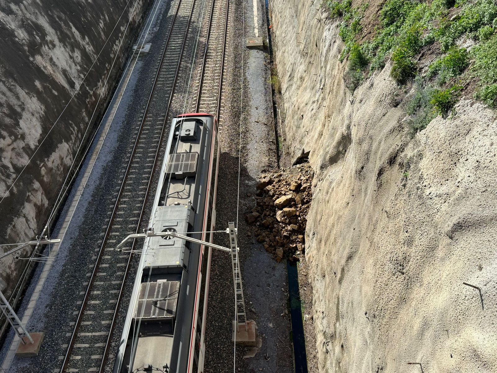Desprendimiento en un muro junto a la vía del cercanías C1 en Málaga