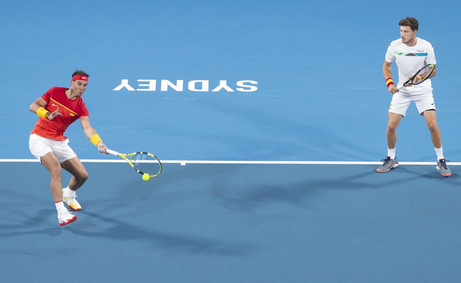 Rafa Nadal golpea la pelota en el duelo de dobles junto a Pablo Carreño.