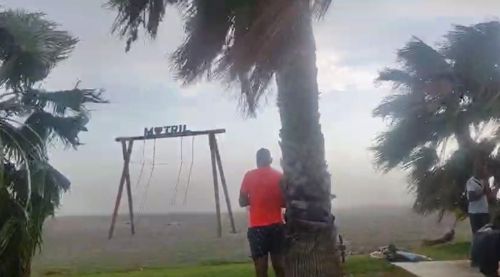 Varias personas en Motril esperando el autobús para irse de la playa durante el reventón térmico