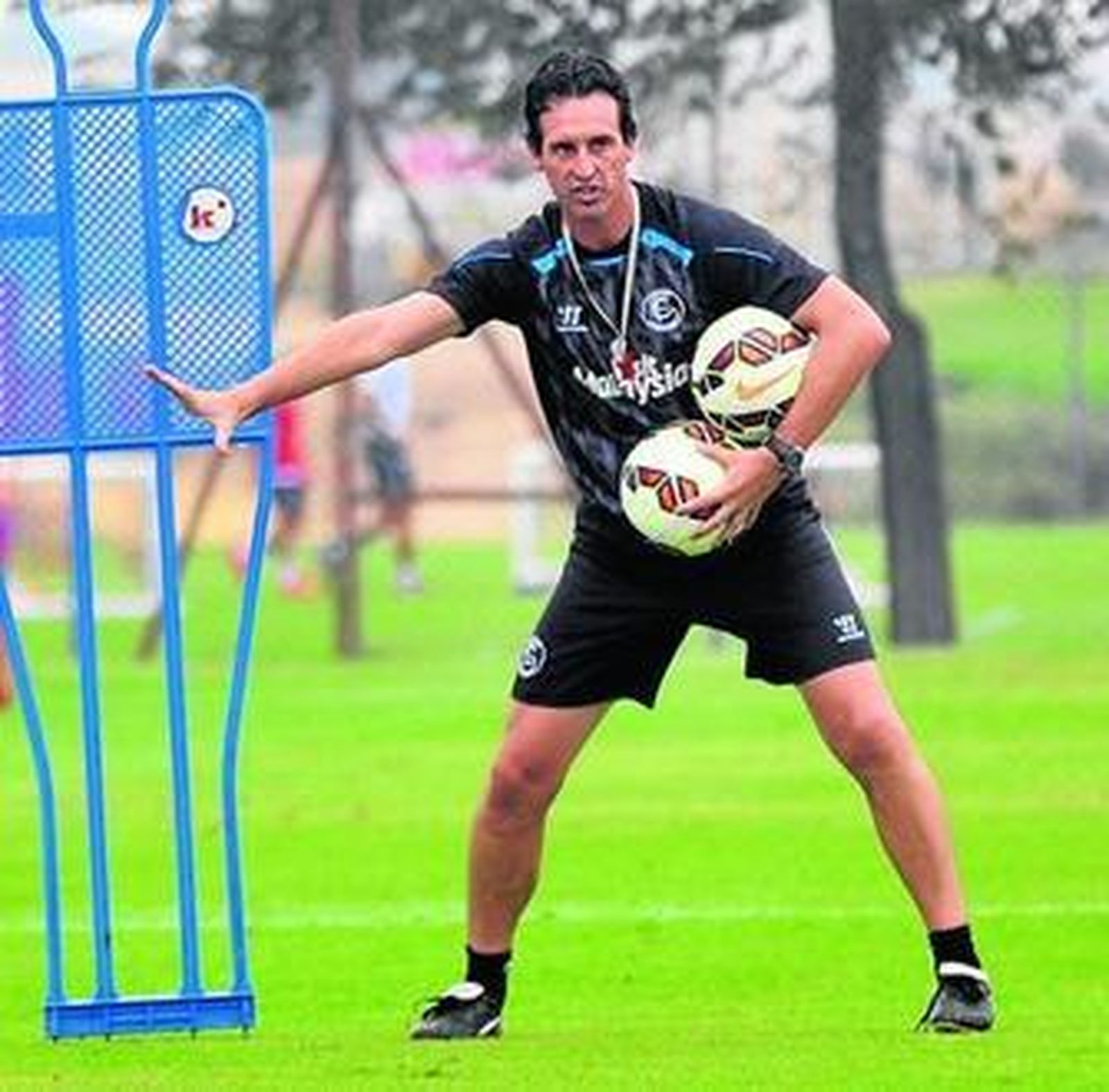 Emery, cargado de balones, da instrucciones a sus jugadores.
