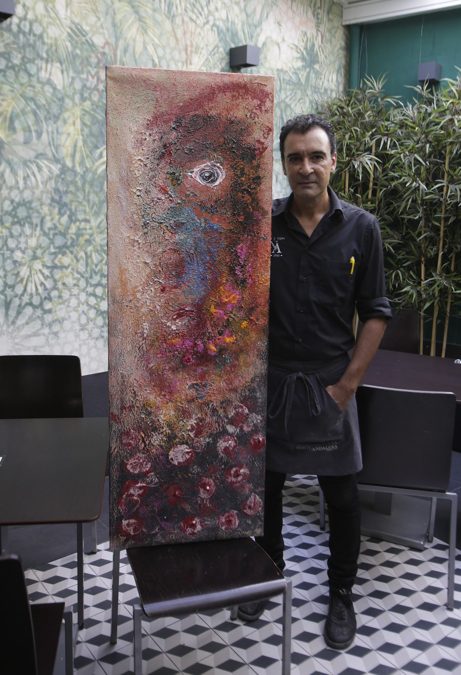 Alfonso Martínez, camarero de La Norte, con un último cuadro que pintó.