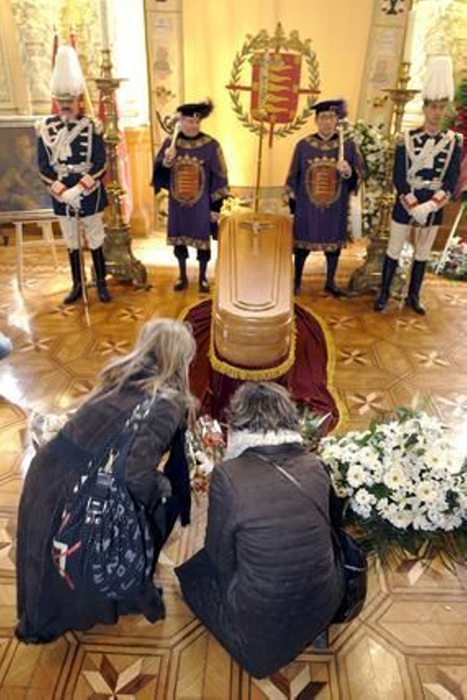 Dos señoras dejan flores a los pies del féretro en capilla ardiente del escritor Miguel Delibes.

Foto: agencias
