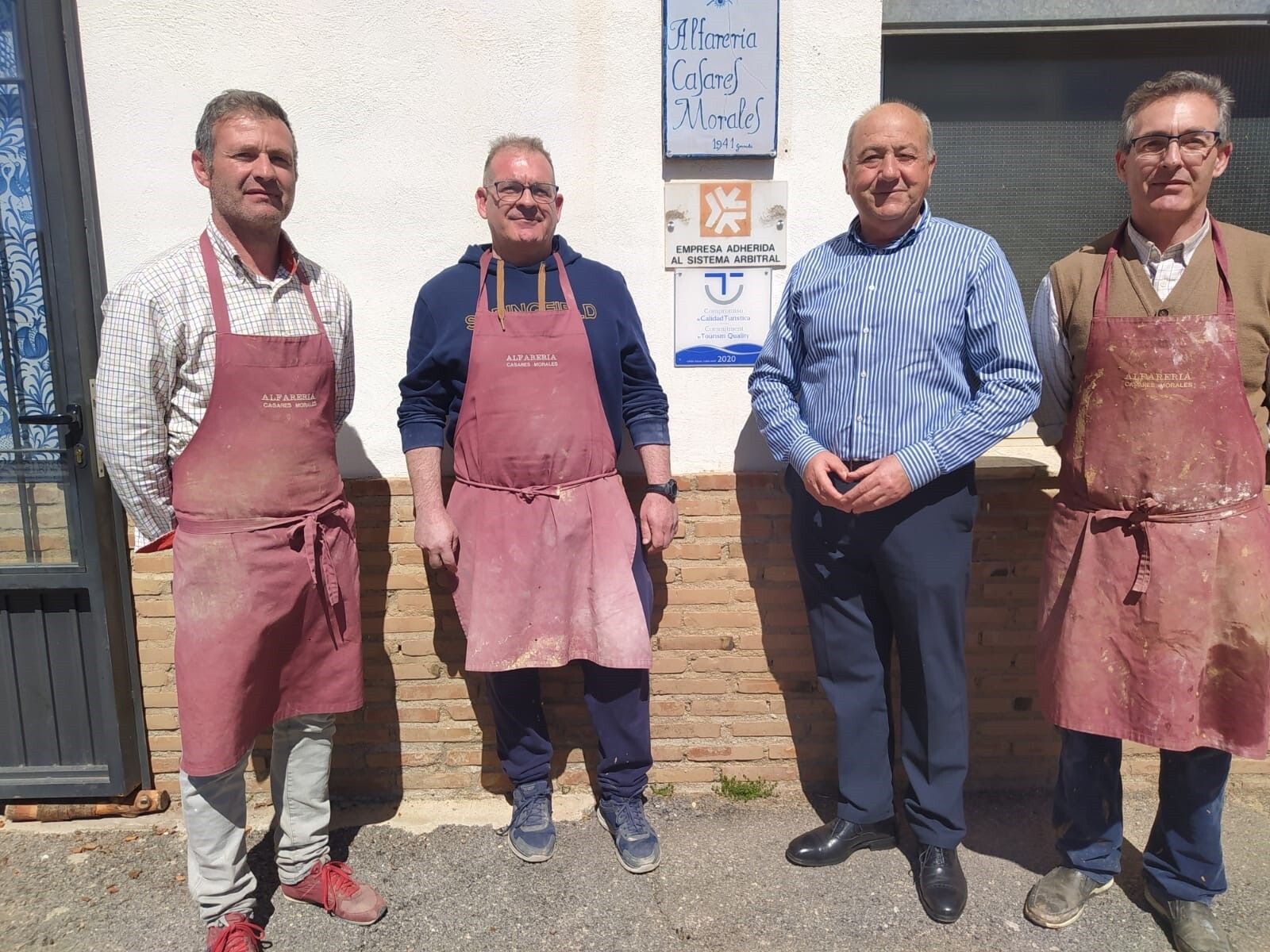 El diputado, Juan Antonio Palomino, posa frente a un establecimiento con el sello de adhesión al sistema arbitral de consumo