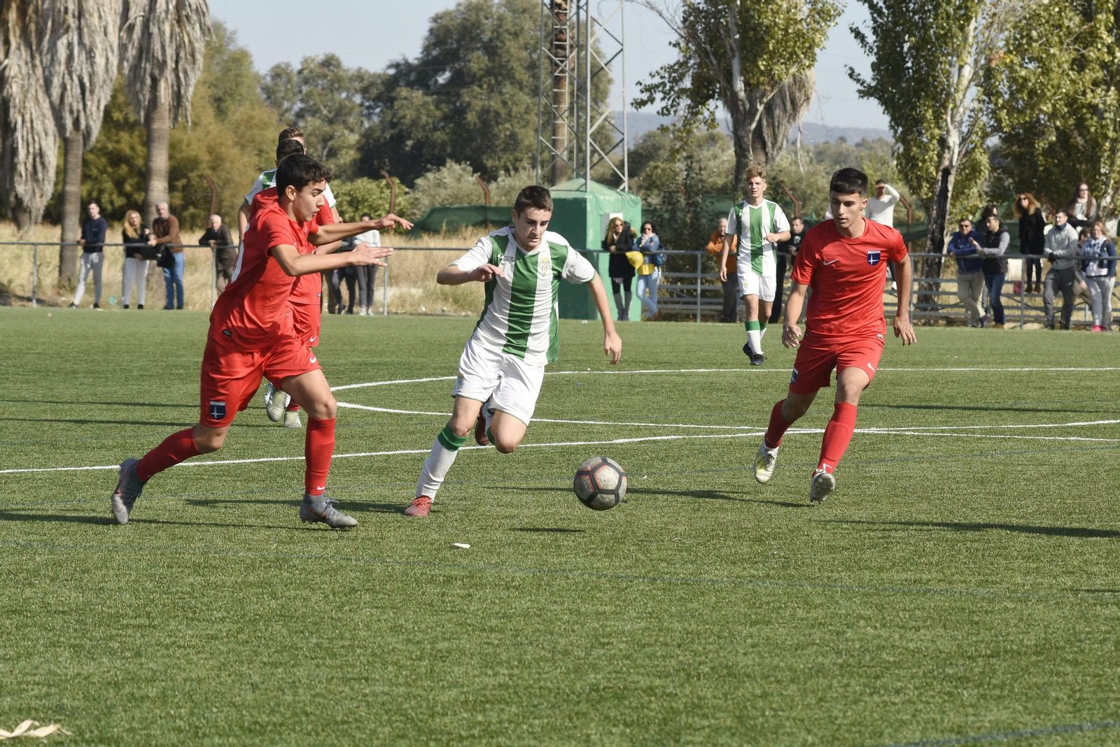 Un jugador del Córdoba de División de Honor Cadete se cuela entre dos jugadores del Altair.