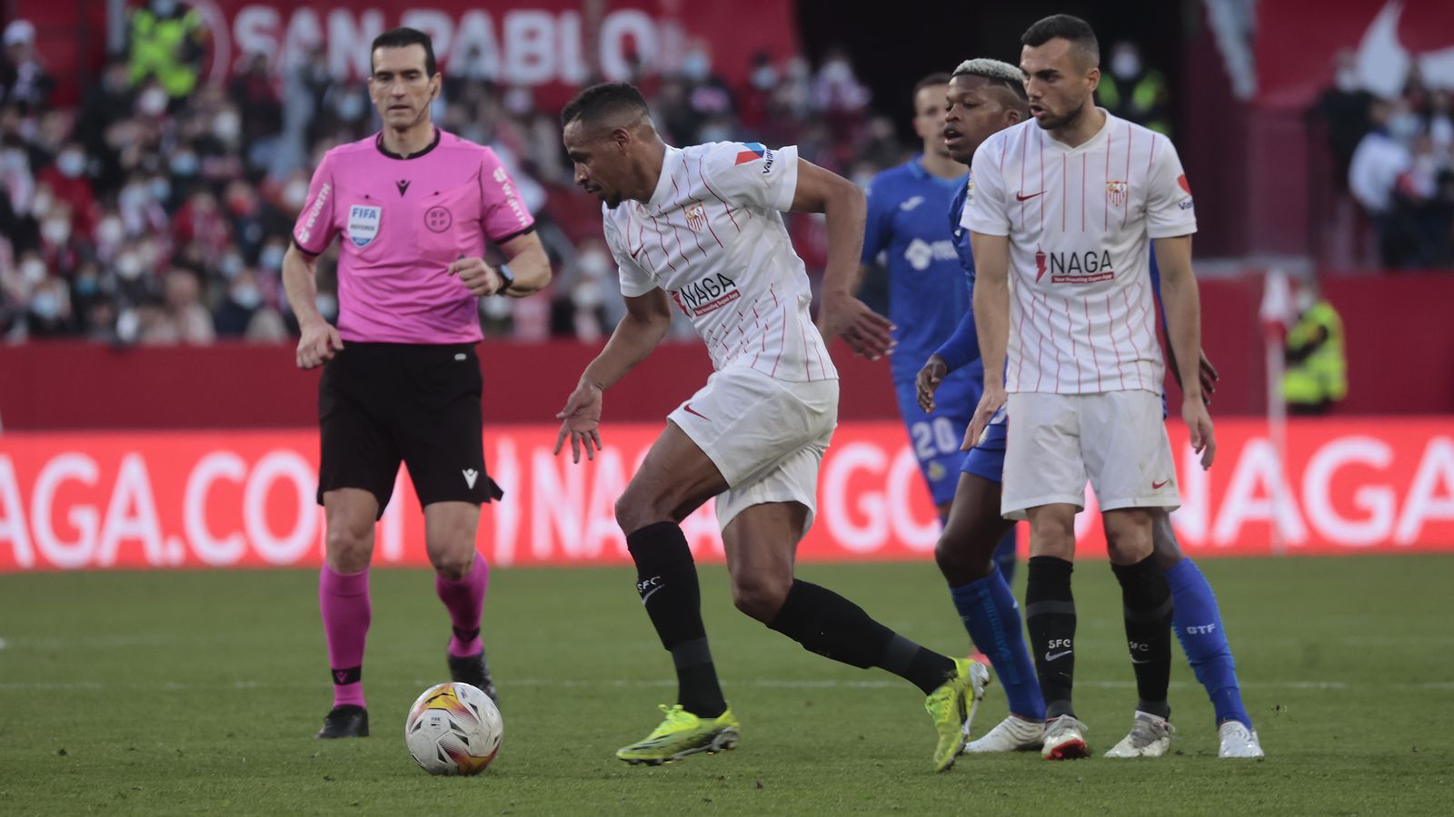 Fernando se lleva el balón delante de Martínez Munuera y Joan Jordán.