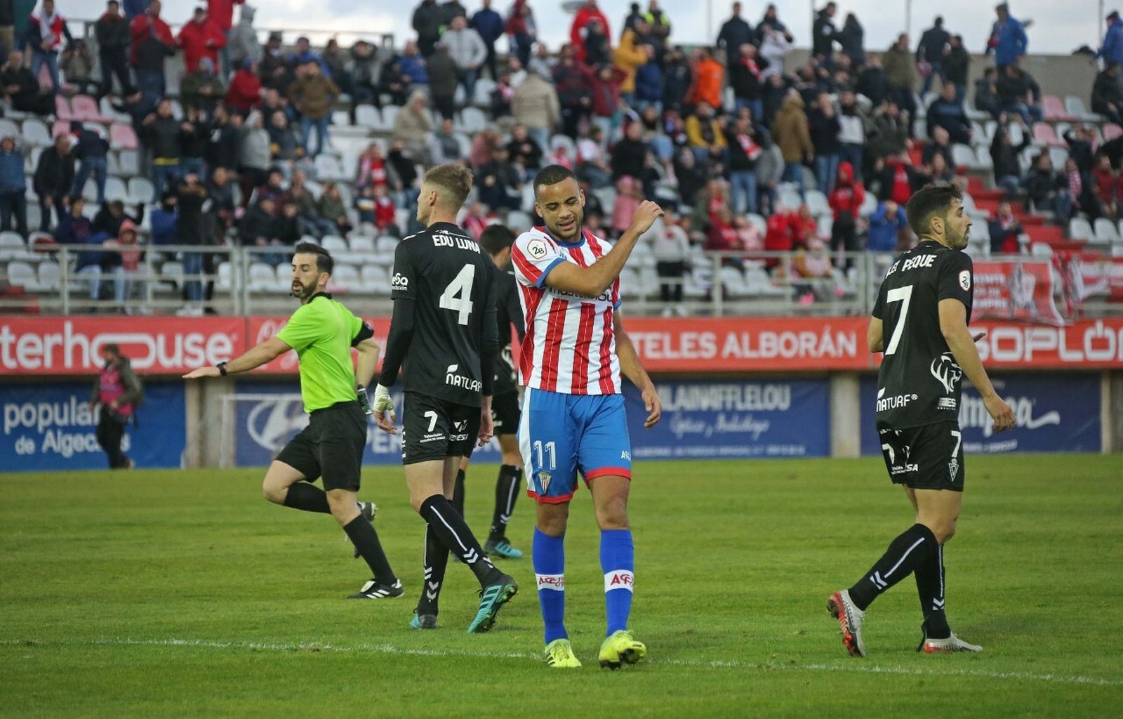 Pablo Ganet se lamenta ante dos jugadores del Murcia.