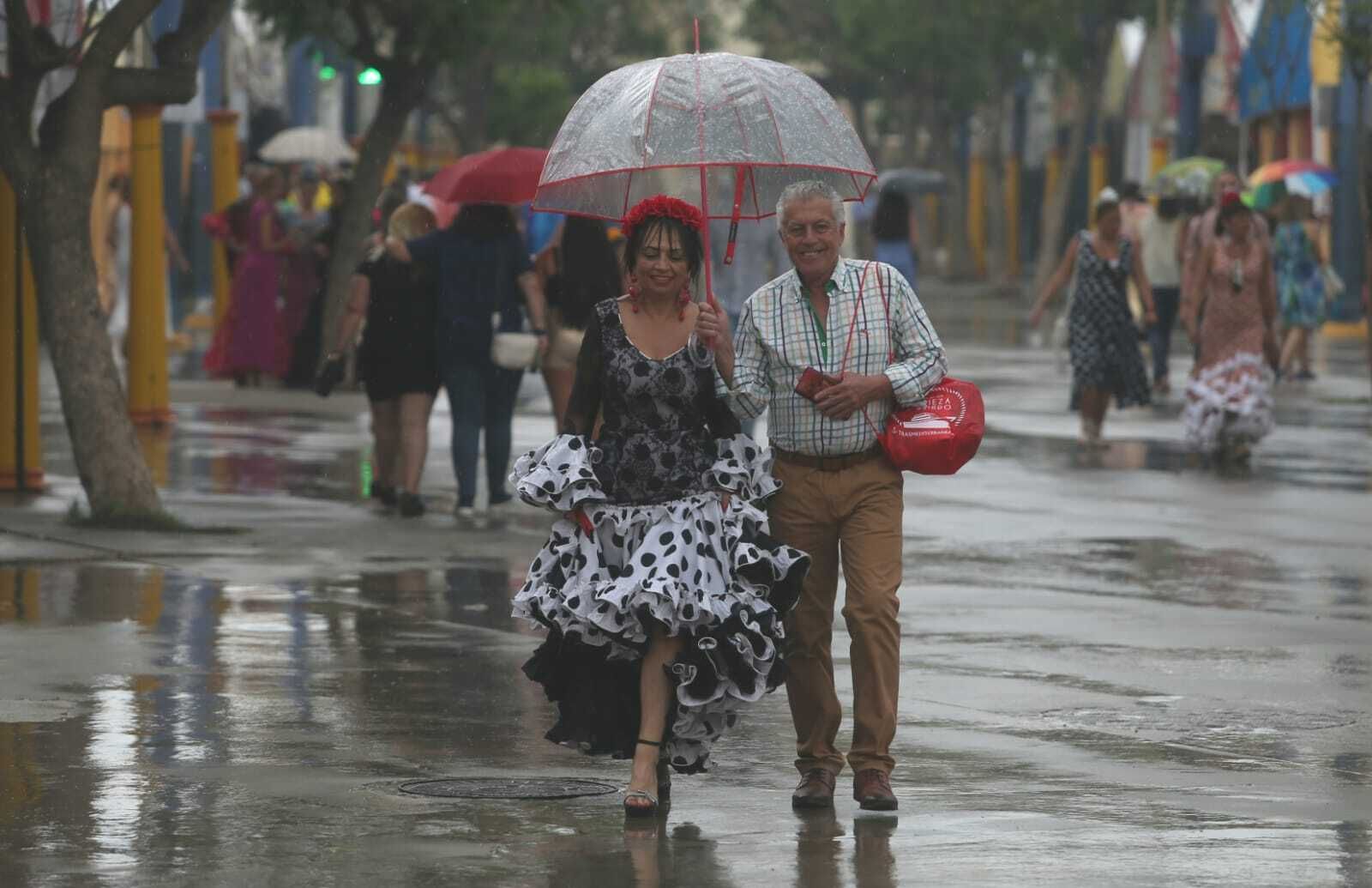 Una pareja con un paraguas en el recinto ferial, este domingo.