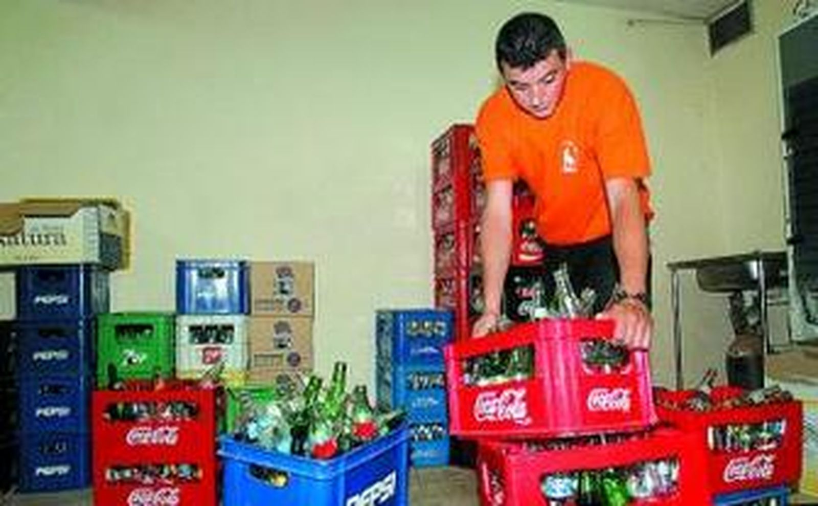 El encargado de un bar constata la escasez de cajas de refrescos.