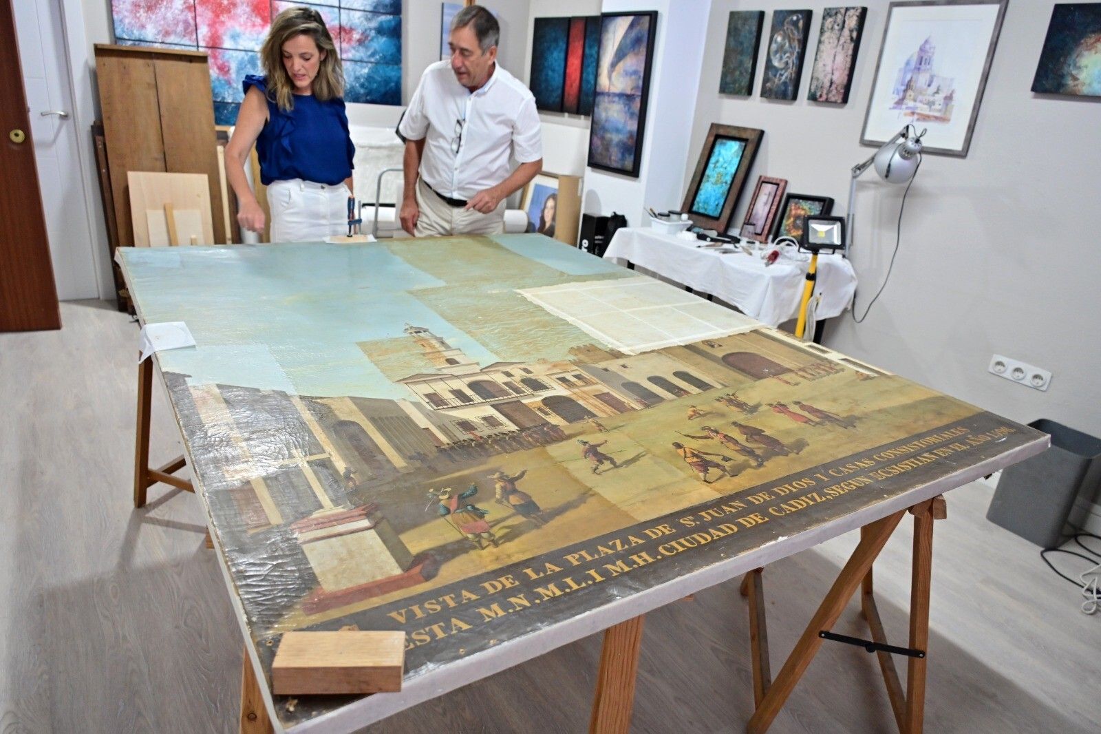 La concejala Maite González y el restaurador Pedro Macías ante el cuadro del Museo gaditano.
