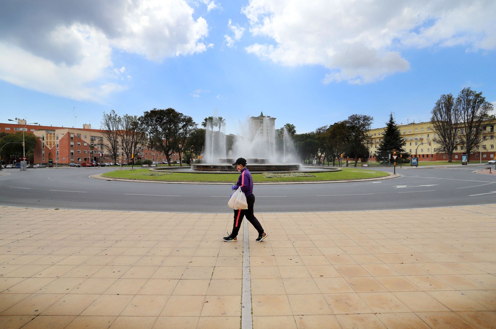 Una mujer con la compra en una Avenida Andalucía vacía por el confinamiento domiciliario.