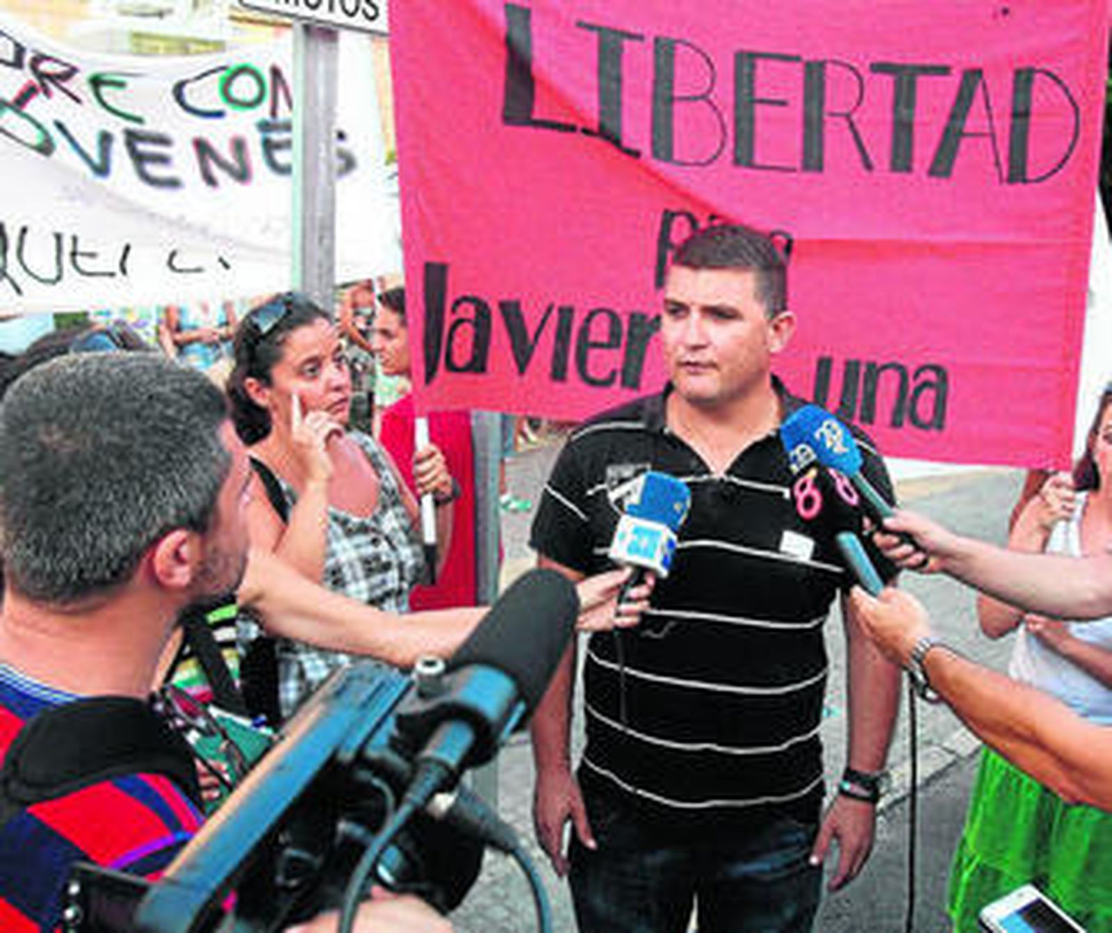 Daniel López Luna habla con la prensa entre pancartas de apoyo a su hermano, ayer por la tarde.