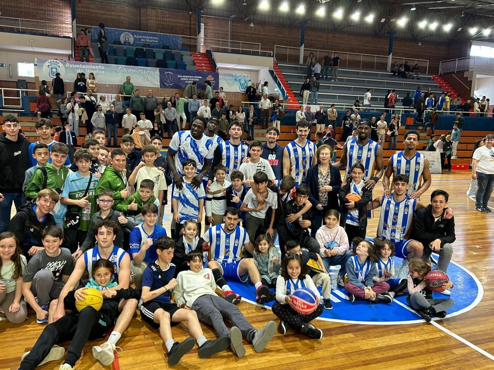 Jugadores del Huelva Comercio posan con varios aficionados.