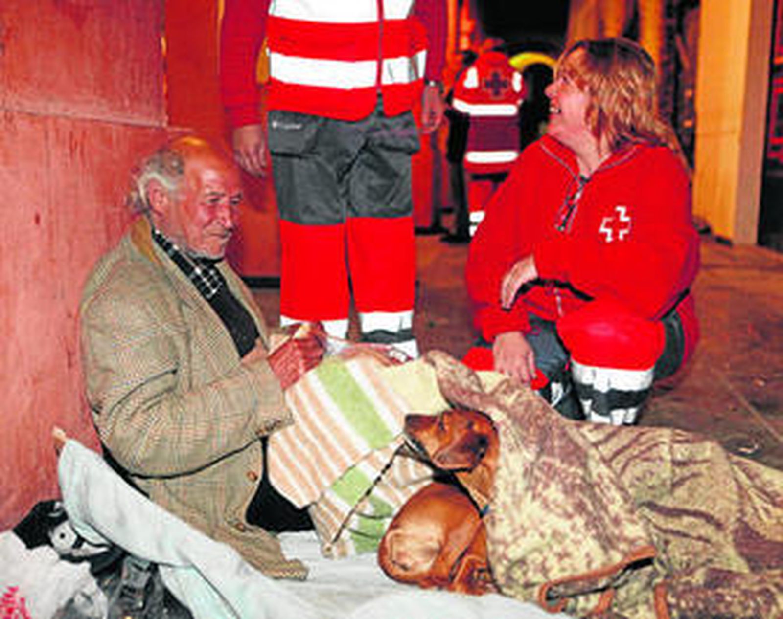 Una voluntaria atiende a un 'sin techo'.