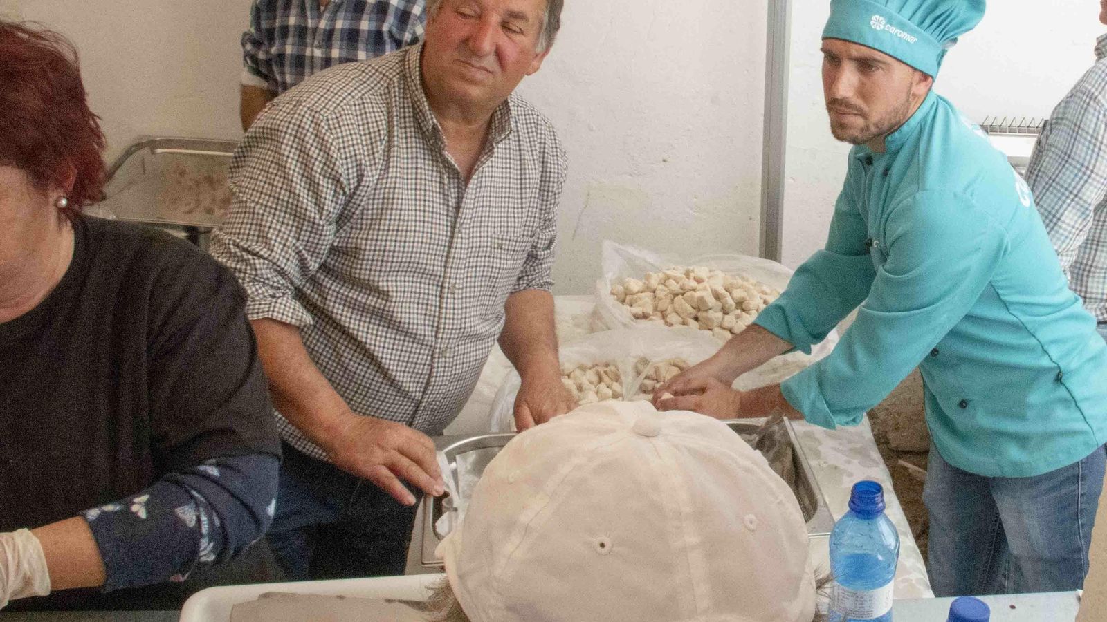 José y su hijo preparan el adobo junto a otros miembros de la comitiva.