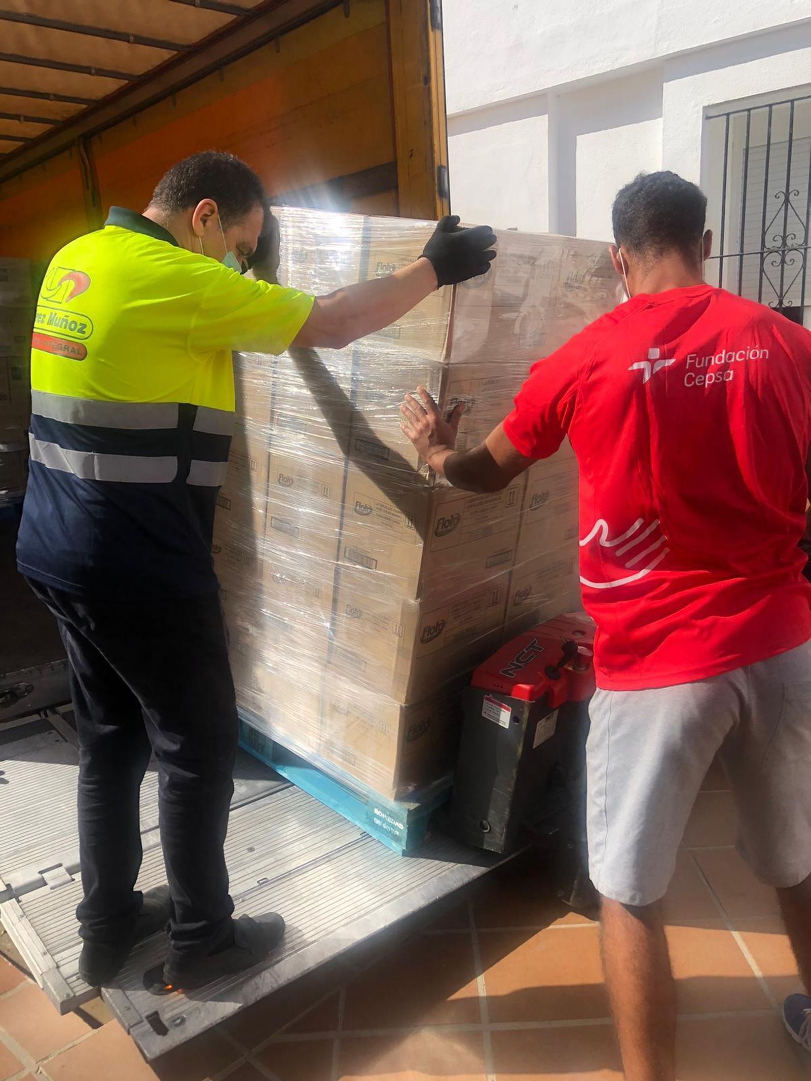 Un empleado de Pérez Muñoz y un integrante de la Fundación Cepsa cargan el producto.