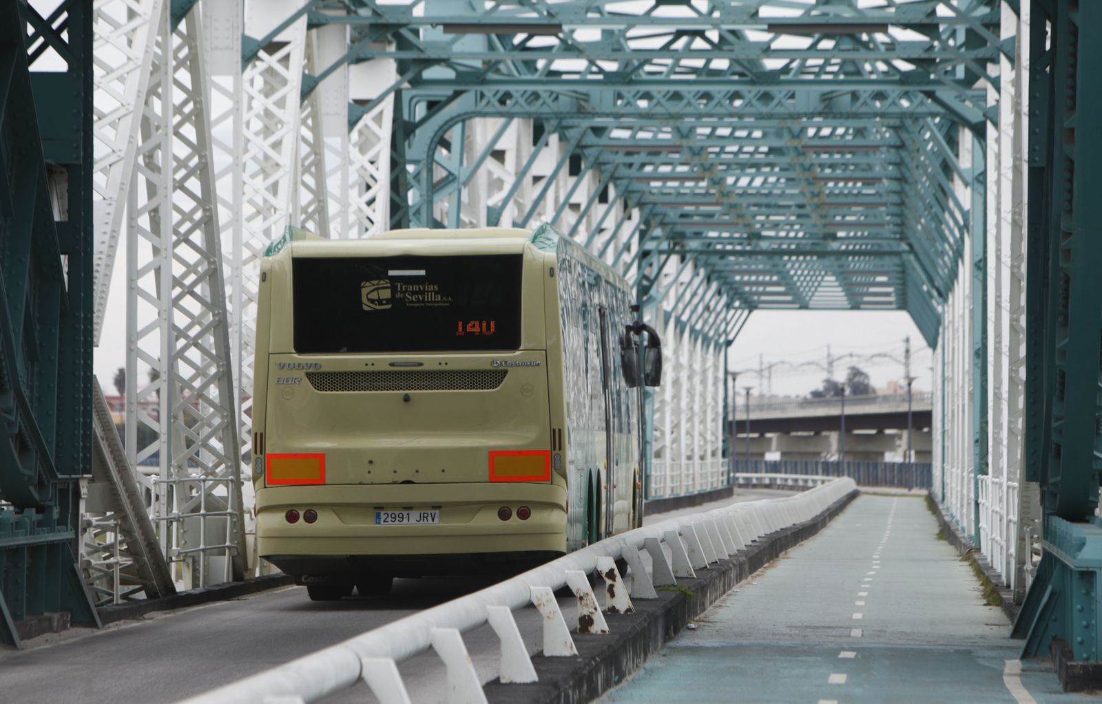 Un autobús del Consorcio de Transportes de Sevilla por el Puente de Hierro de San Juan.