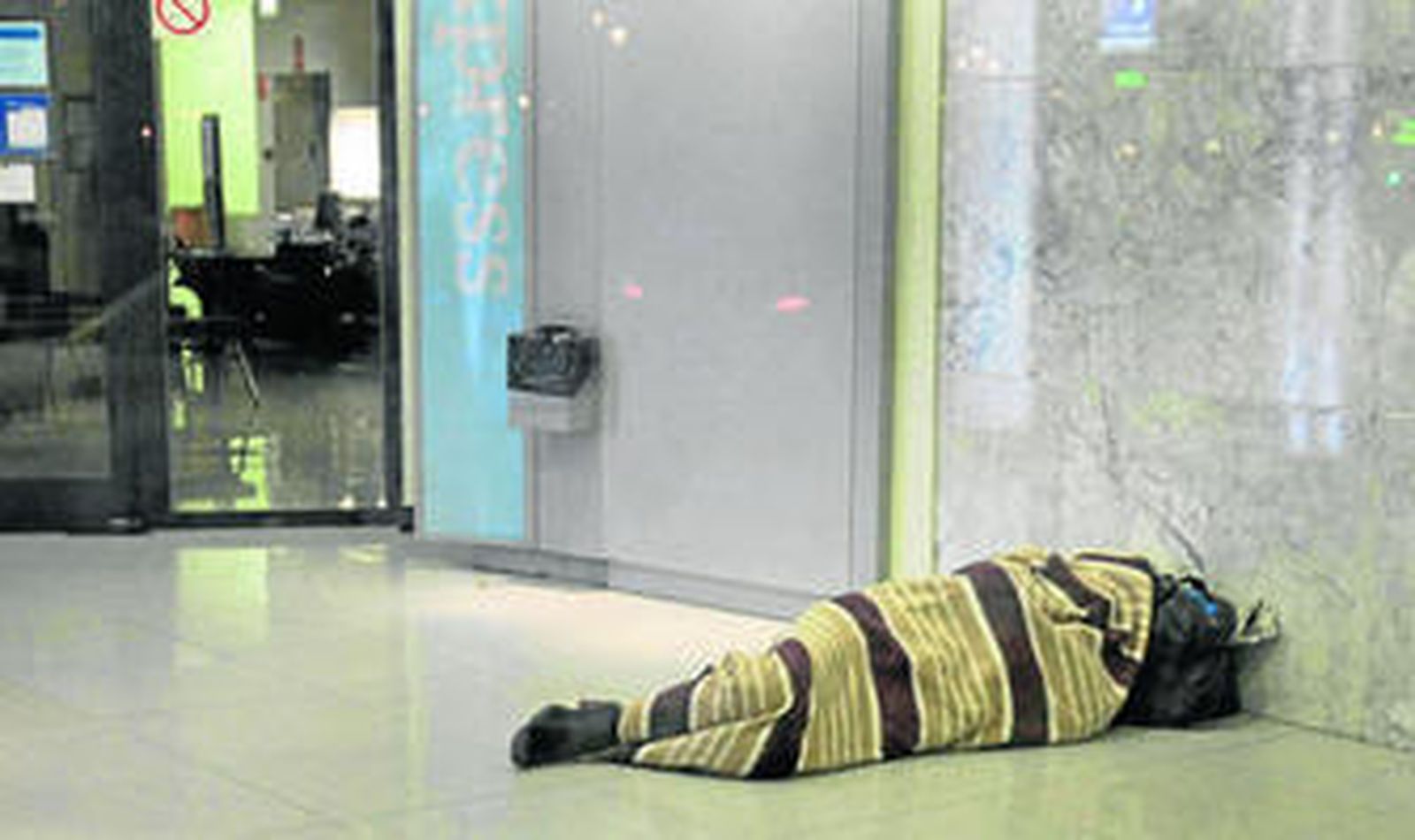 Una persona sin techo pernocta en un cajero de la capital gaditana.