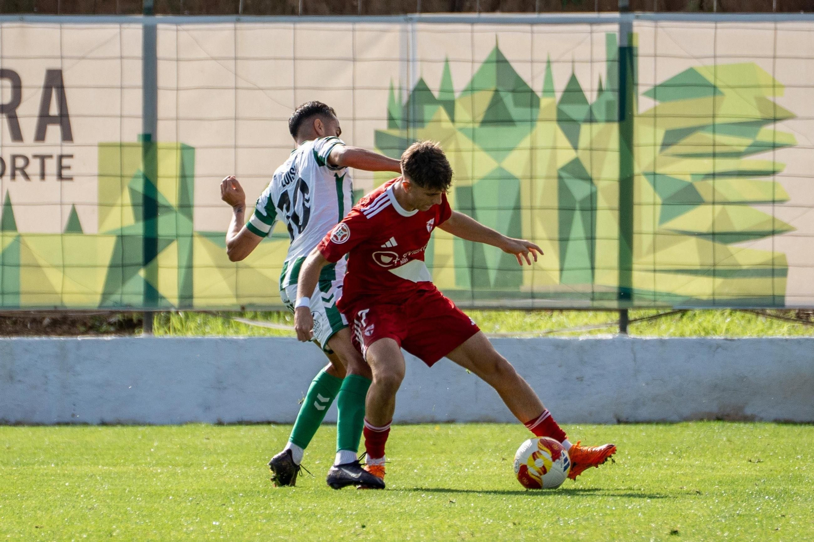 Miguel Sierra aguanta la pelota ante Luismi, capitán del Antequera.