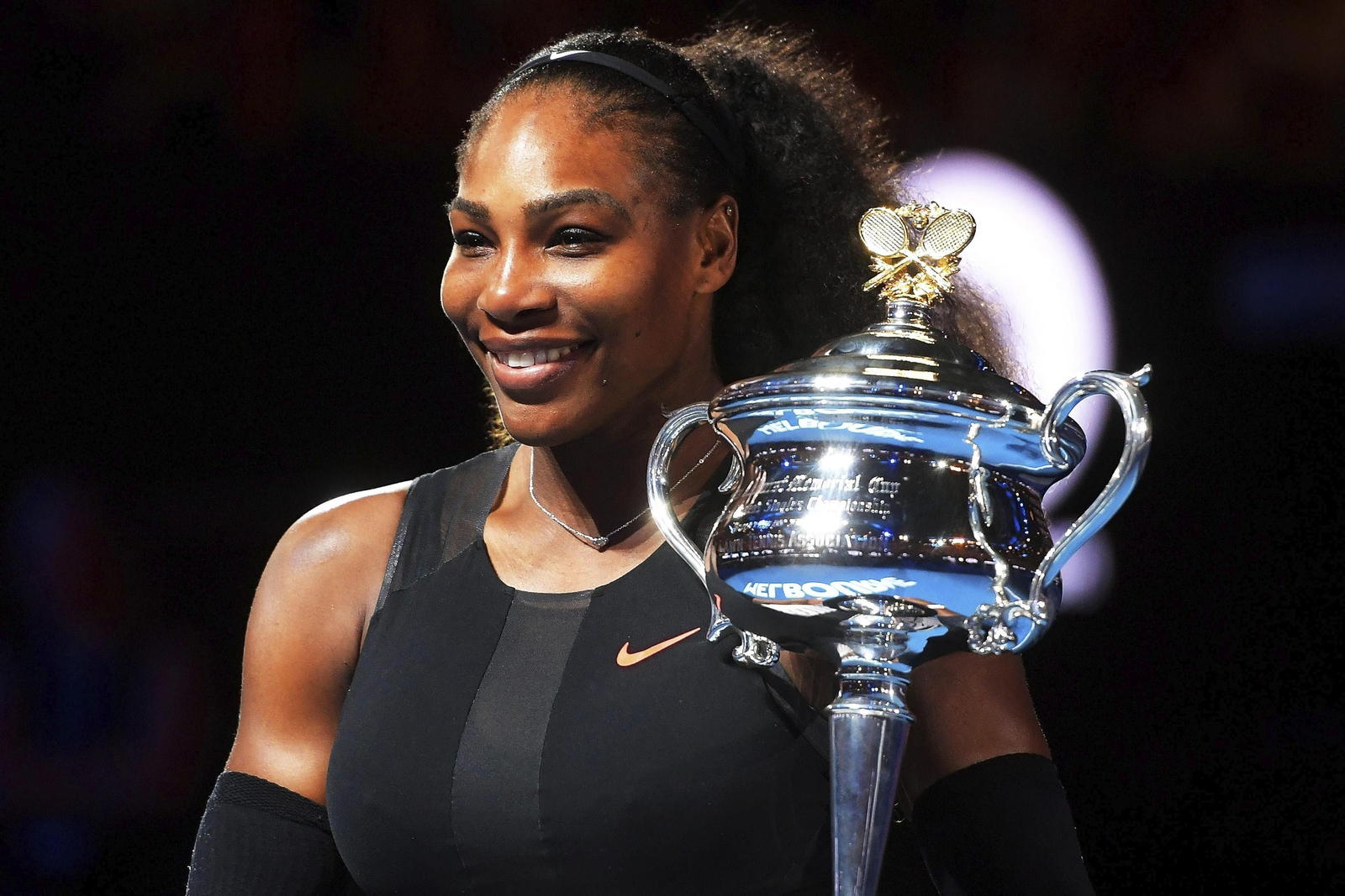 Serena Williams posa con un trofeo de ganadora.