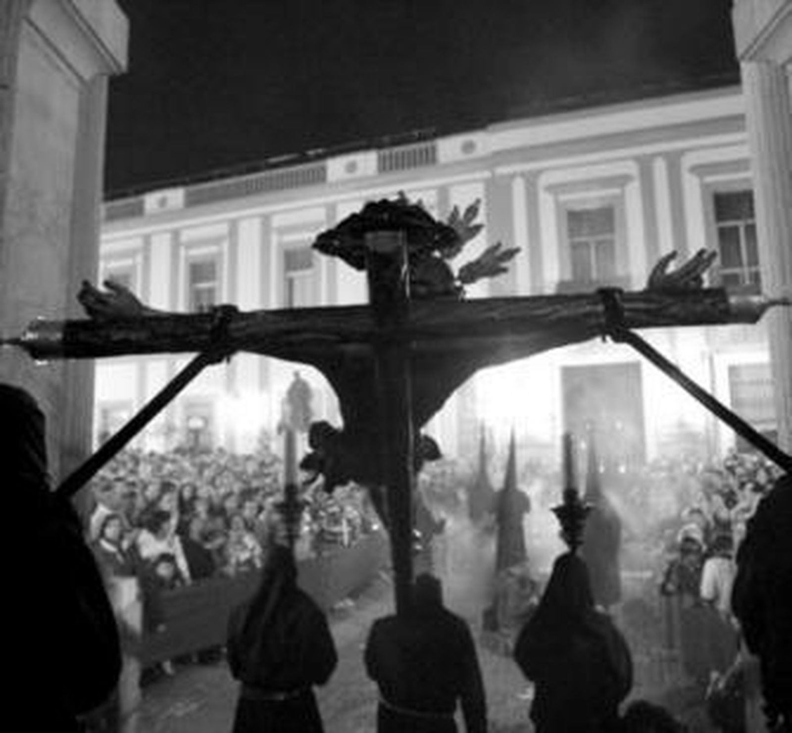 Los tres nazarenos que portan el Cristo de la Salud, a su salida del templo.