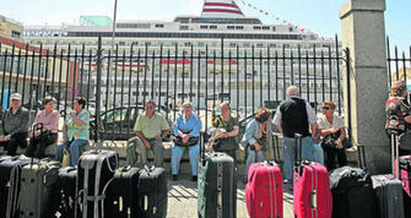 Un grupo de cruceristas espera antes de embarcar en un crucero, en el puerto de Cádiz.