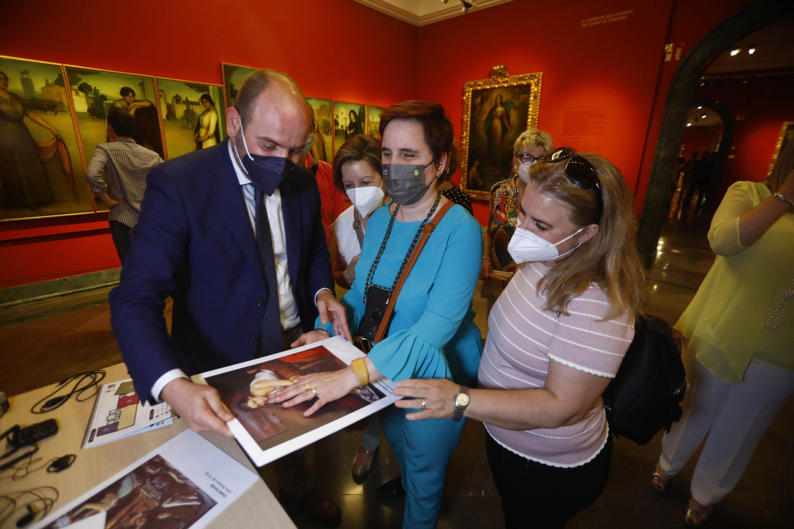 Un grupo de personas ciegas palpan los cuadros de Julio Romero de Torres.