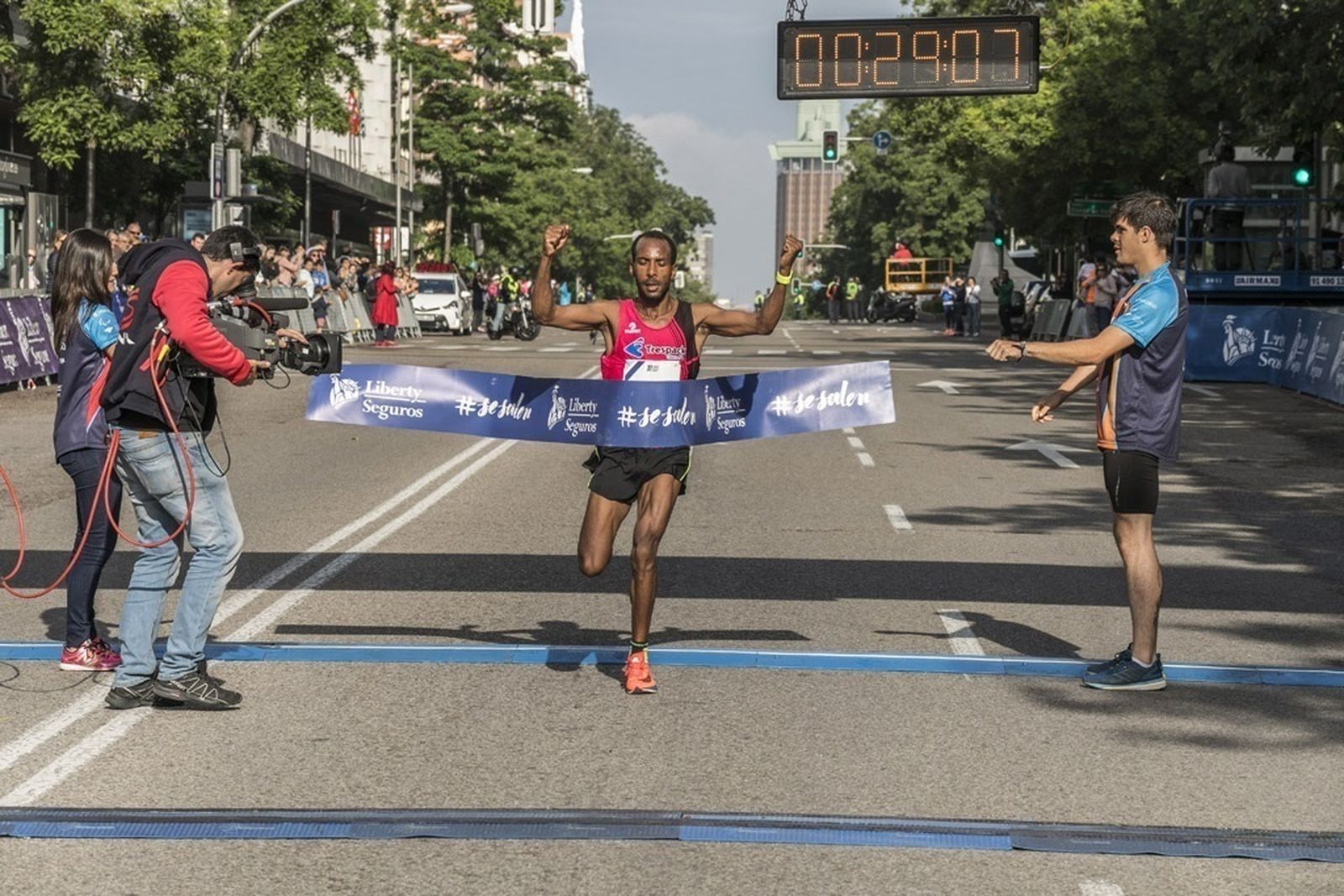 Gizaw Bekele levanta los brazos tras cruzar la línea de meta en la media maratón de Madrid.