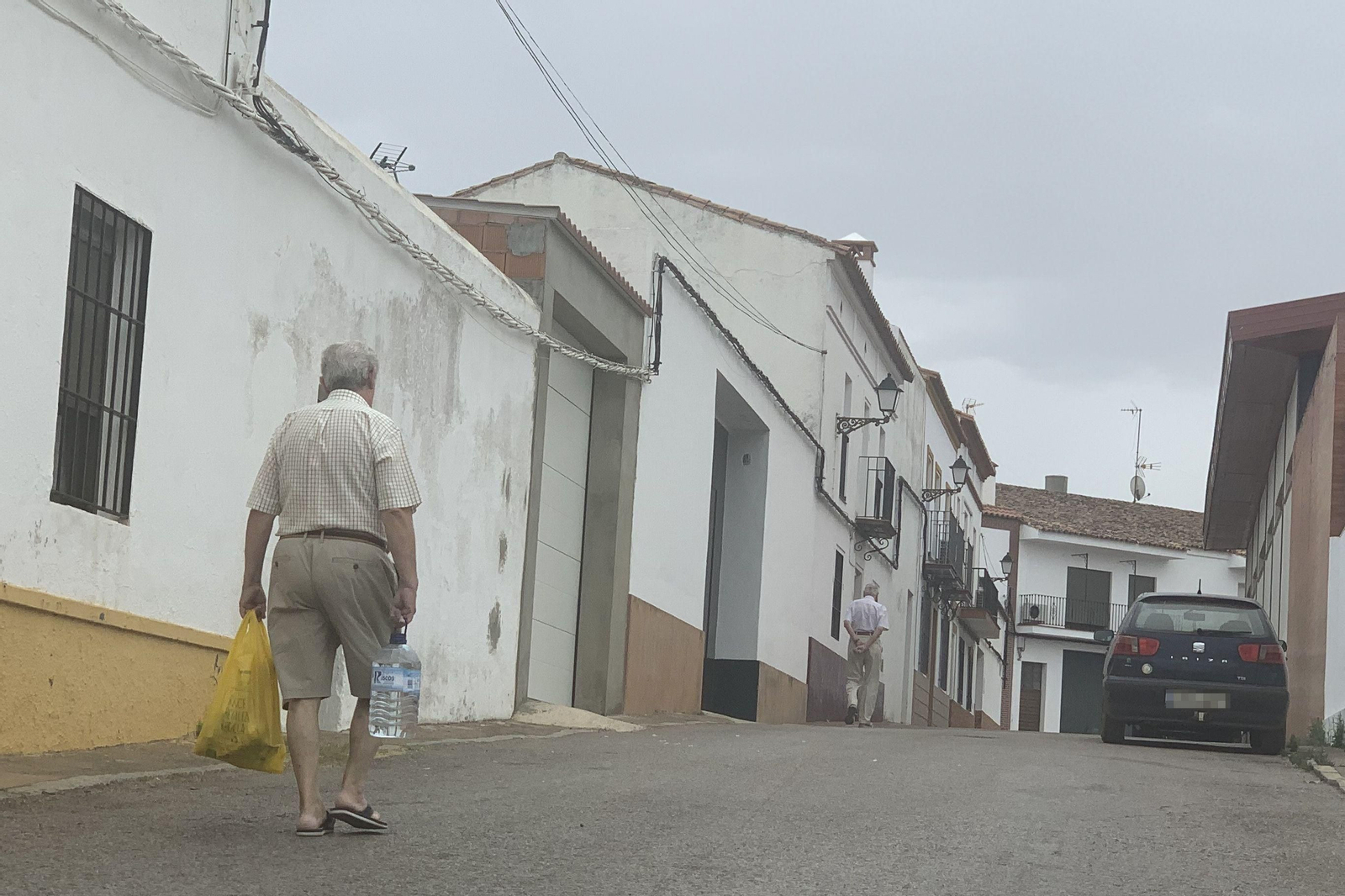 Un hombre lleva una botella de cinco litros de agua.