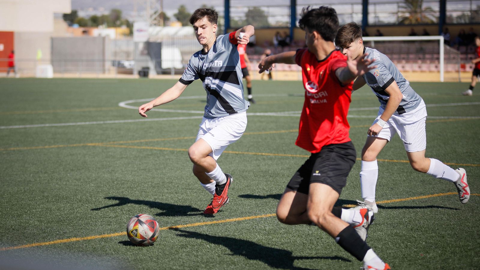 Disputa por el balón entre jugadores de ambos equipos.
