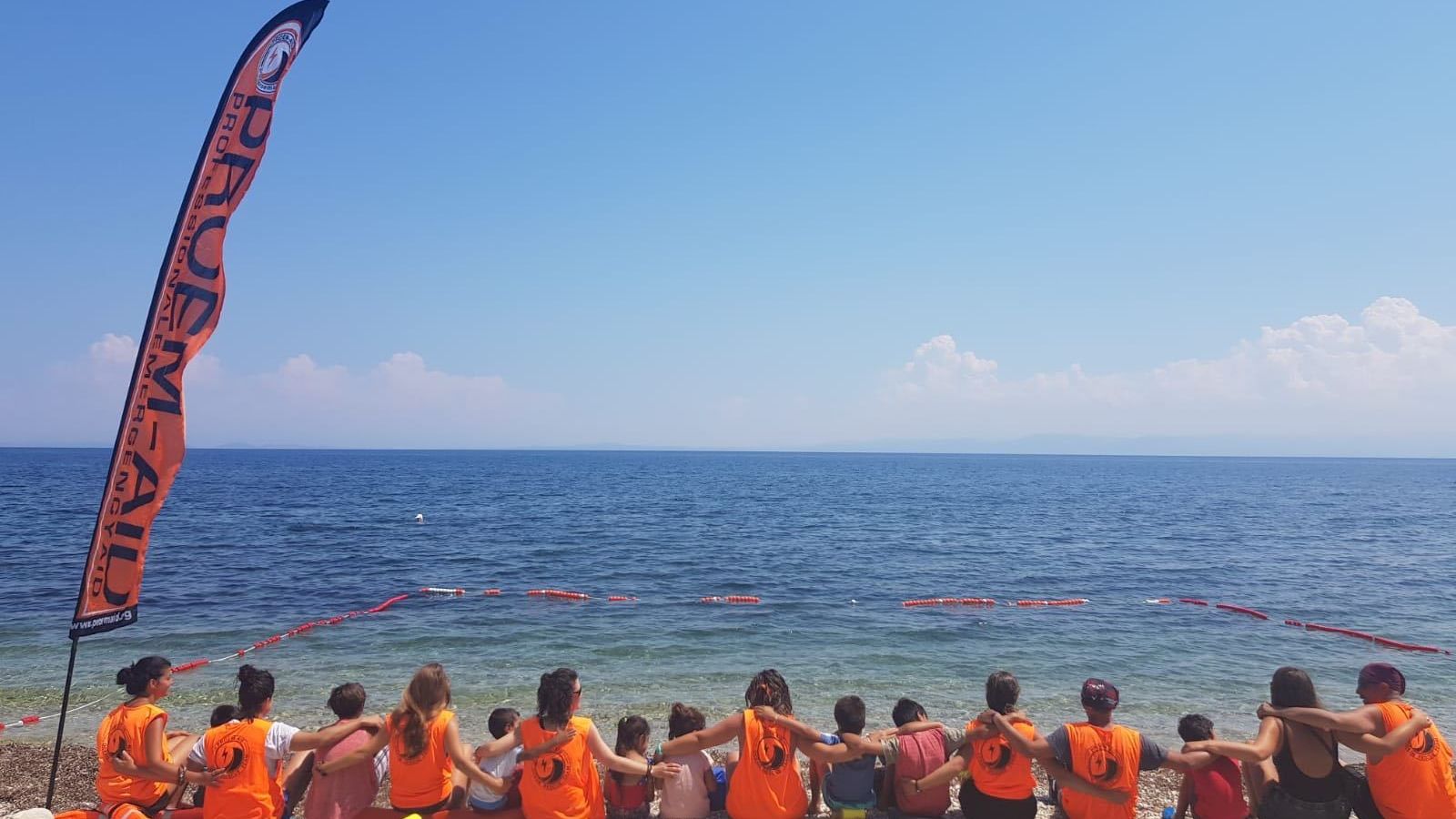Imagen de los voluntarios con los niños refugiados en la playa