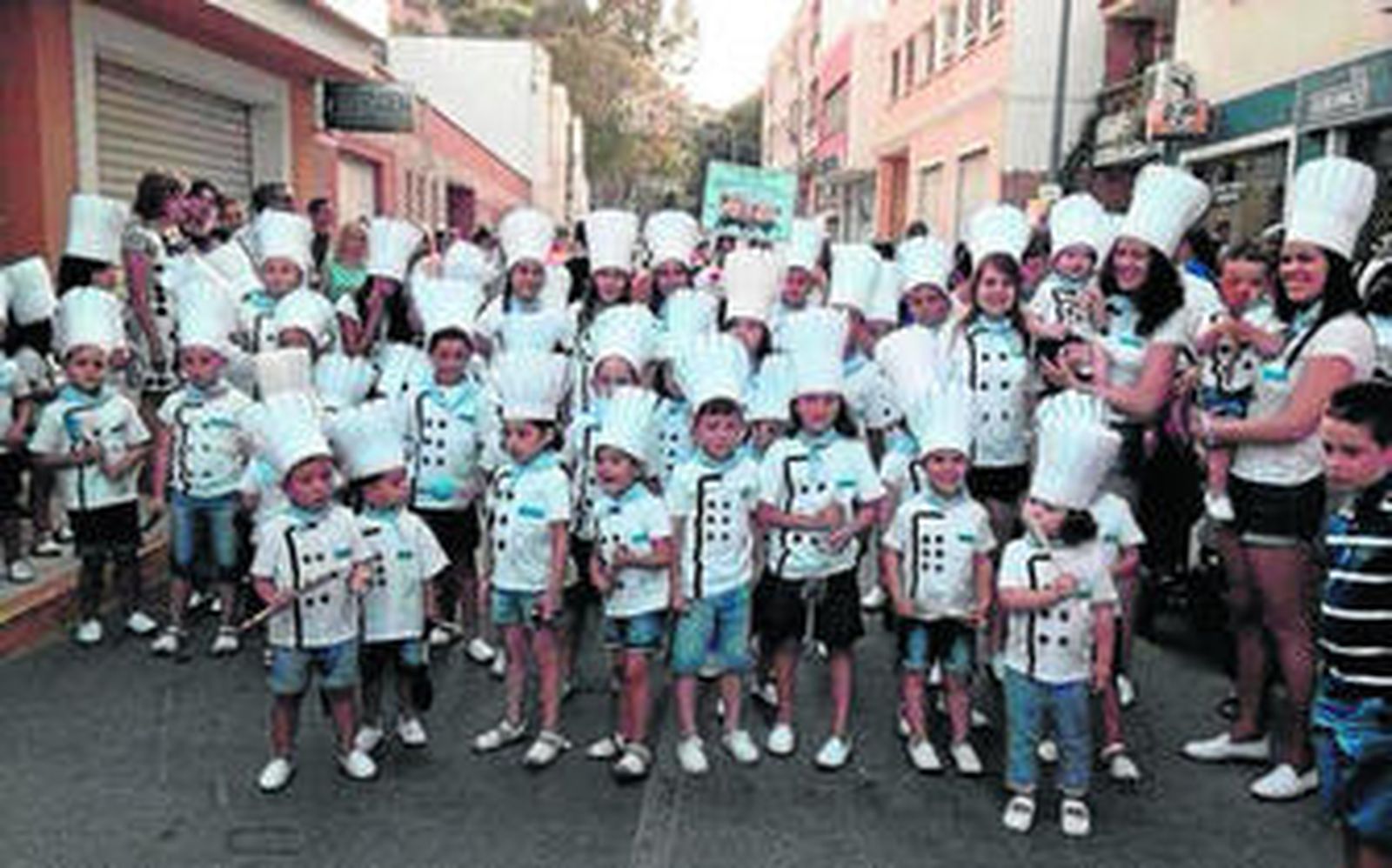 Niños y adultos disfrazados de cocineros.