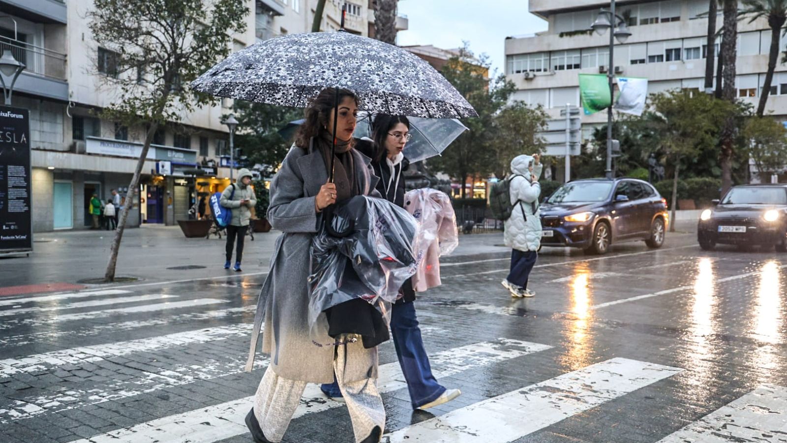 Dos mujeres se pretegen de la lluvia este martes en el centro de Huelva.