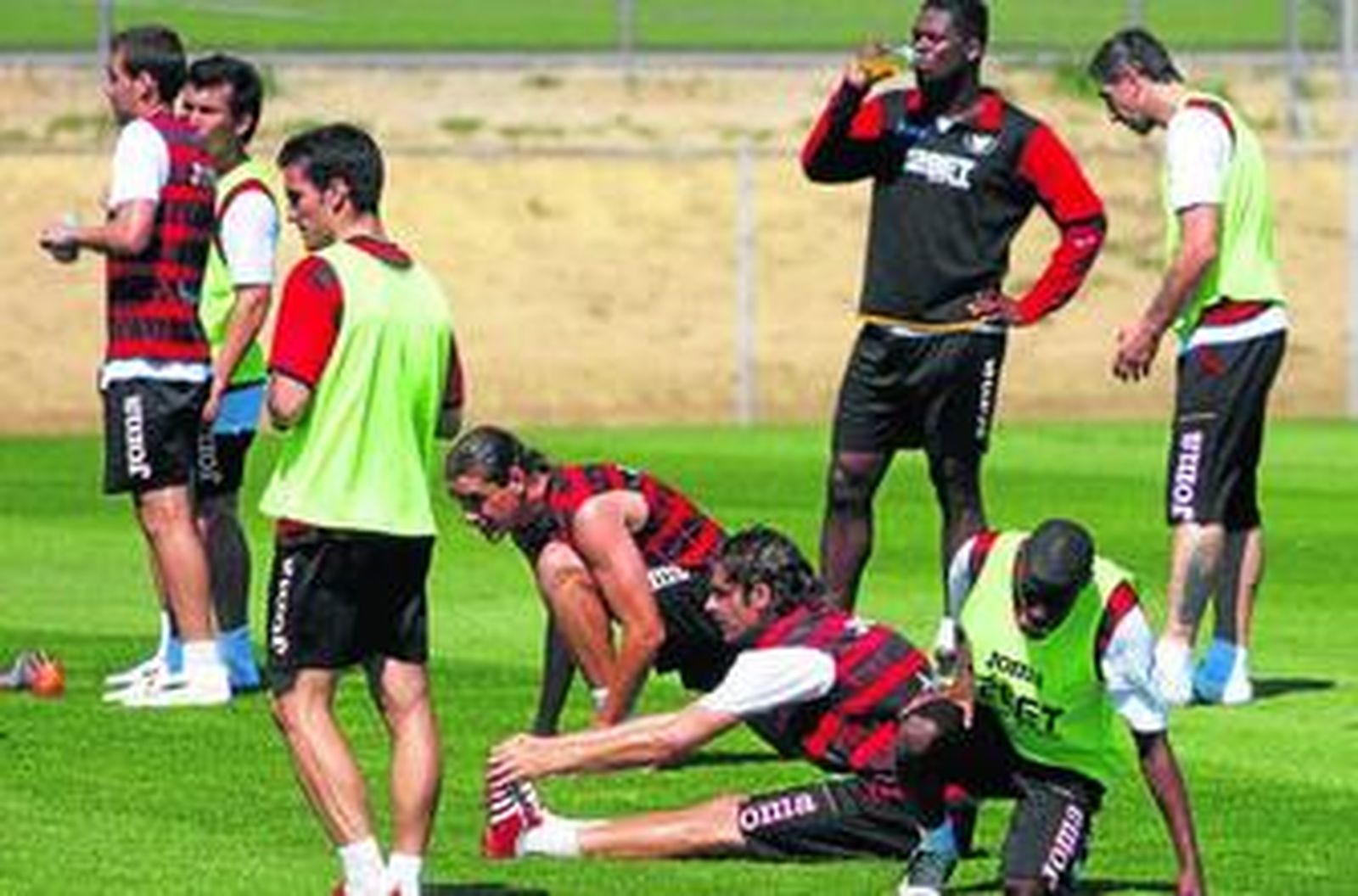 Alfaro y Dragutinovic, entre sus compañeros en plenos estiramientos.