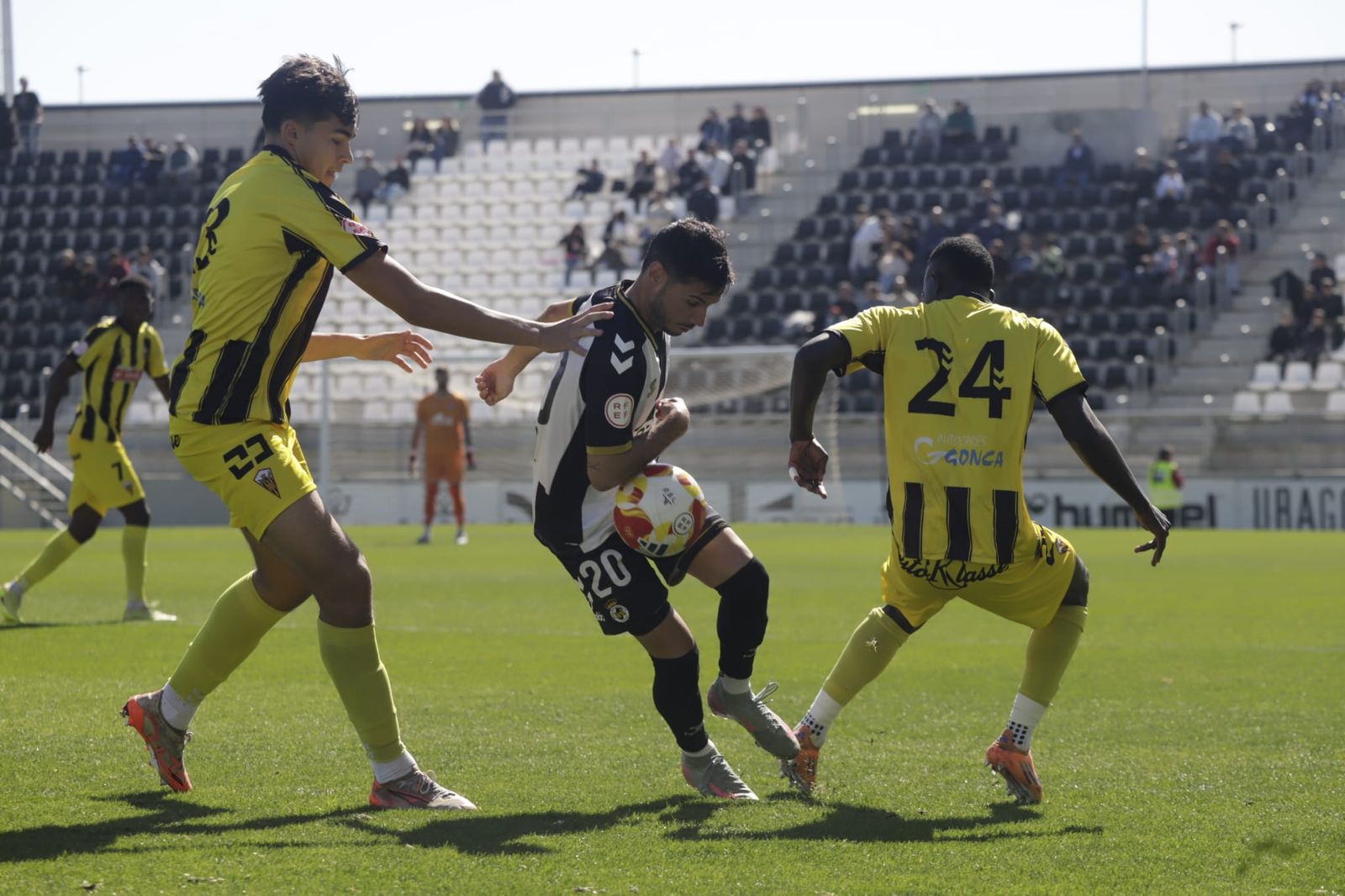Álvaro González, entre dos jugadores del San Roque de Lepe