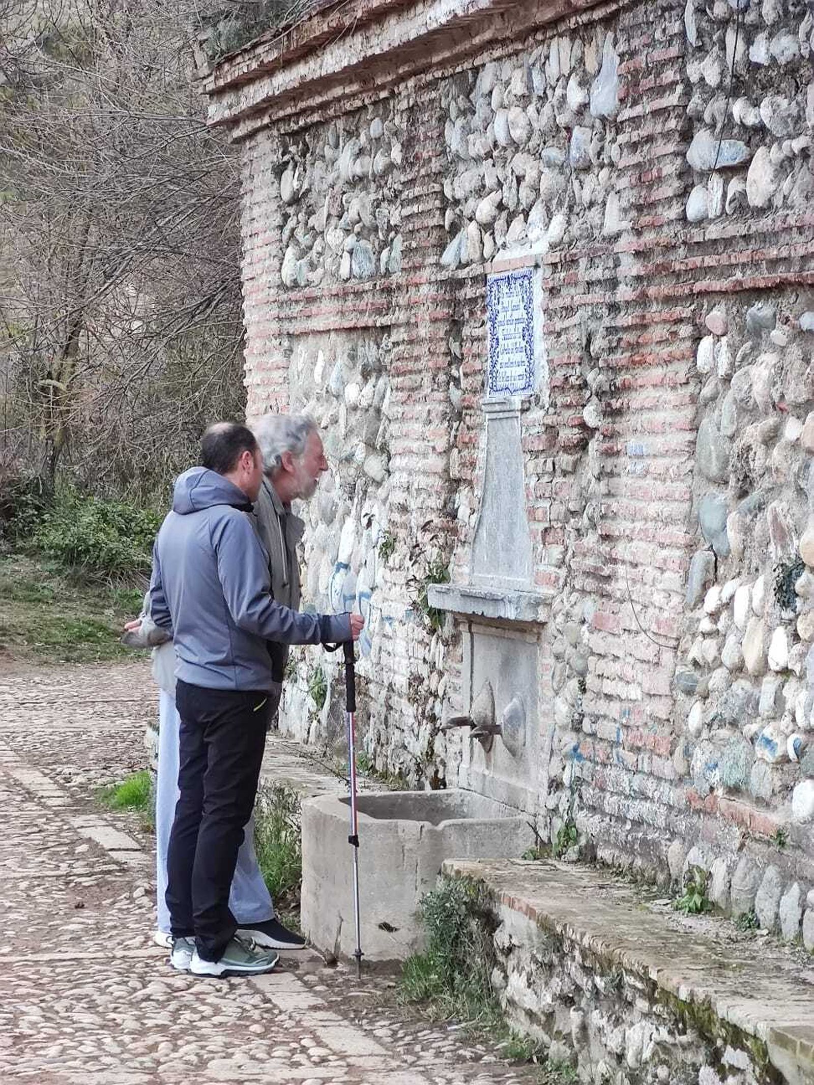 Dos senderistas en la mítica Fuente del Avellano.