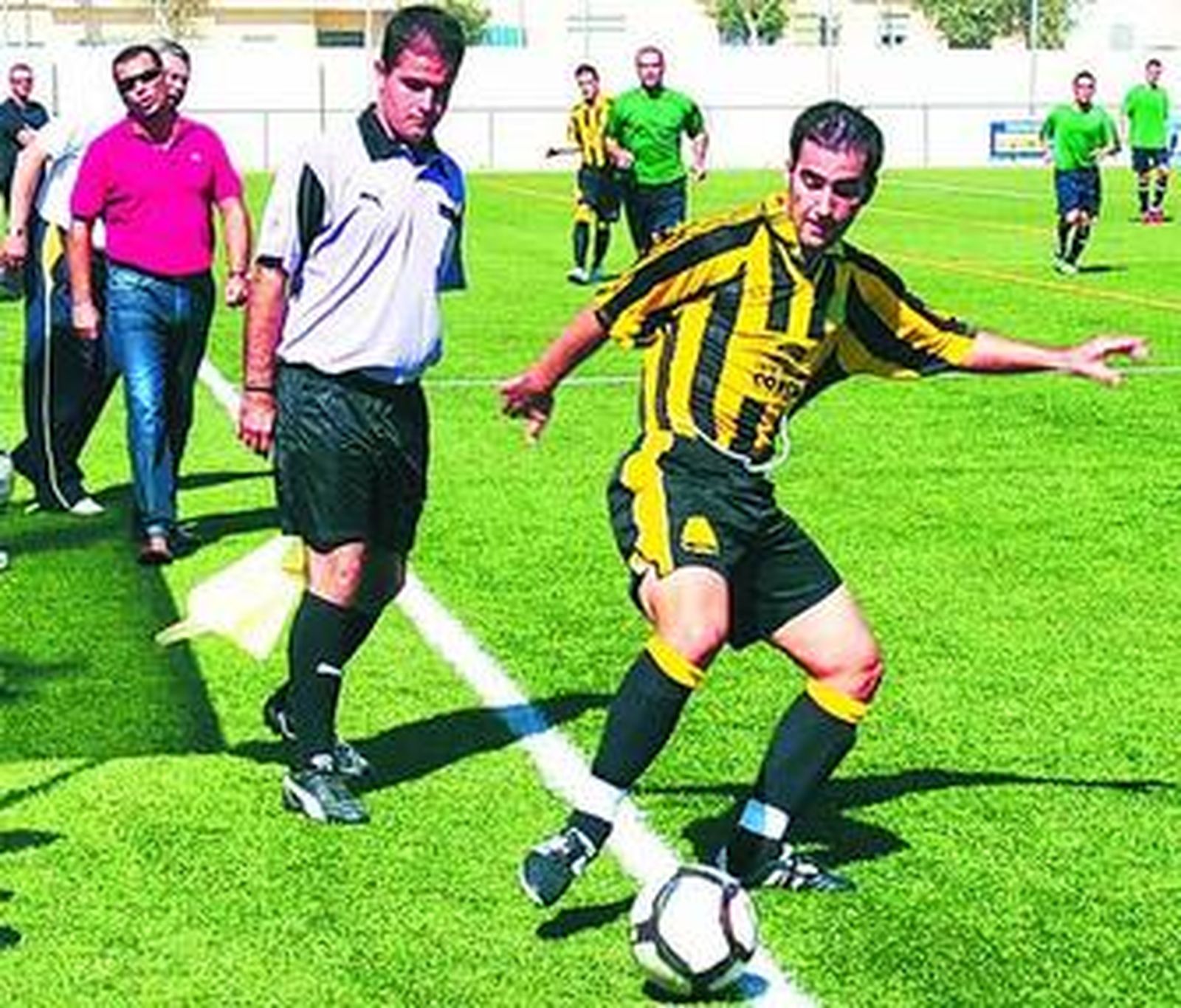 Un jugador bazanero trata de evitar que el balón se pierda por la banda.