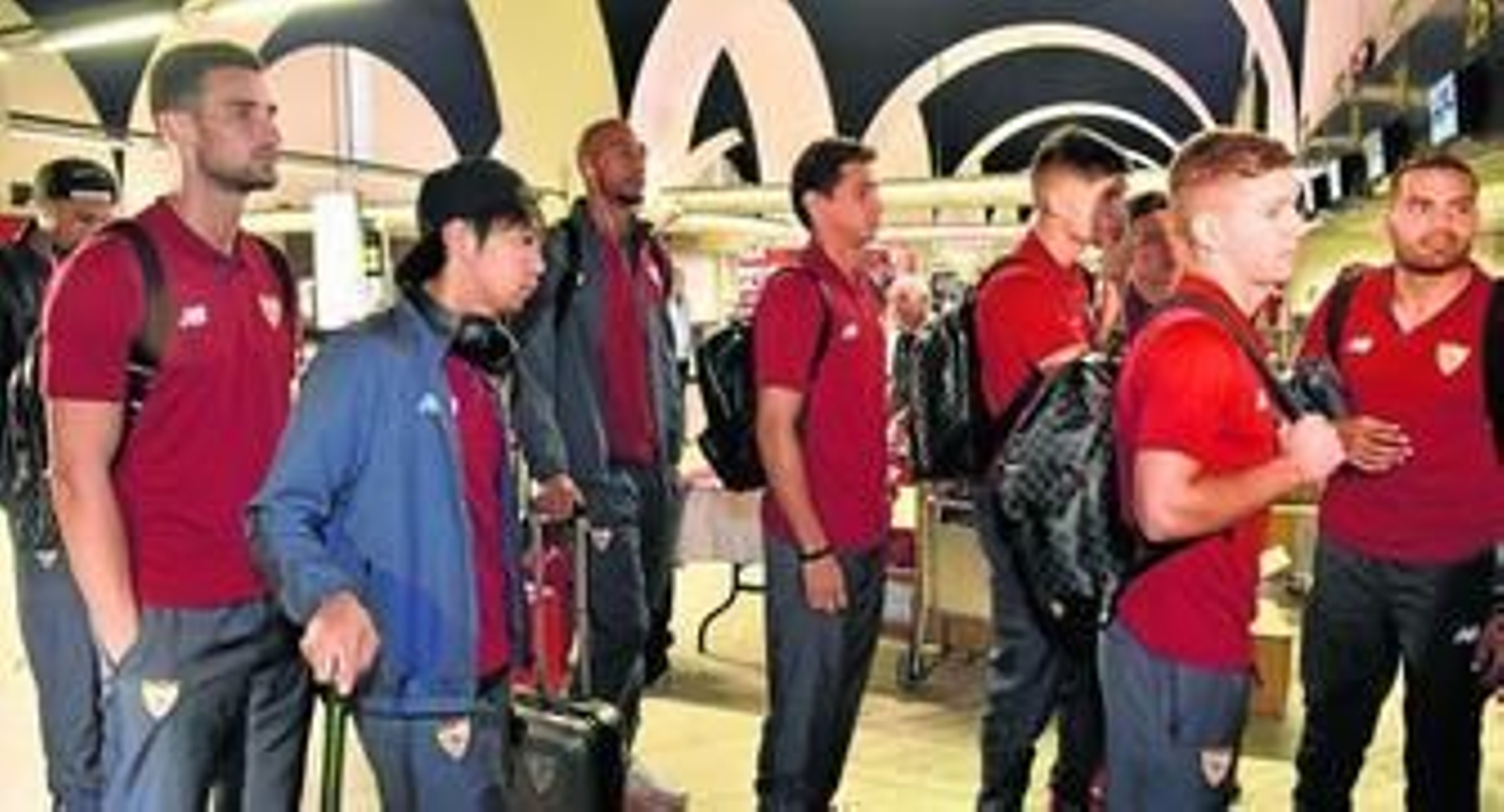 De izquierda a derecha, los sevillistas Sergio Rico, Kiyotake, N'Zonzi, Ganso, Correa, Kranevitter (tapado), Vietto y Mercado, prestos a facturar y embarcar rumbo a Turín.