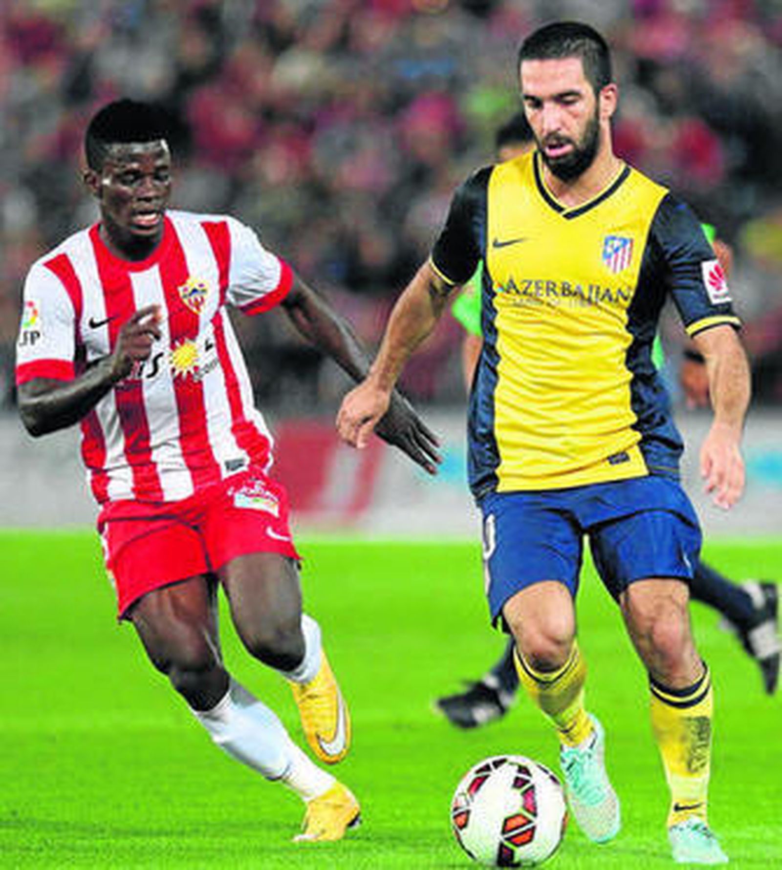 El turco Arda Turan avanza con la pelota acosado por Azeez.