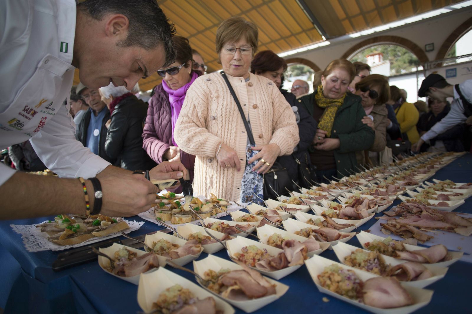 Cocinero realiza preparaciones ante los asistentes al evento.