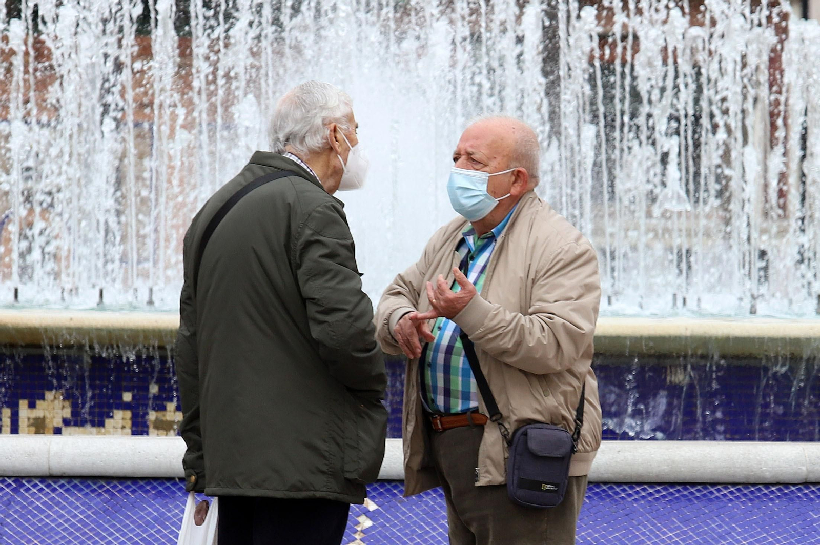 Dos onubenses conversan en la Plaza de las Monjas con sus mascarillas.